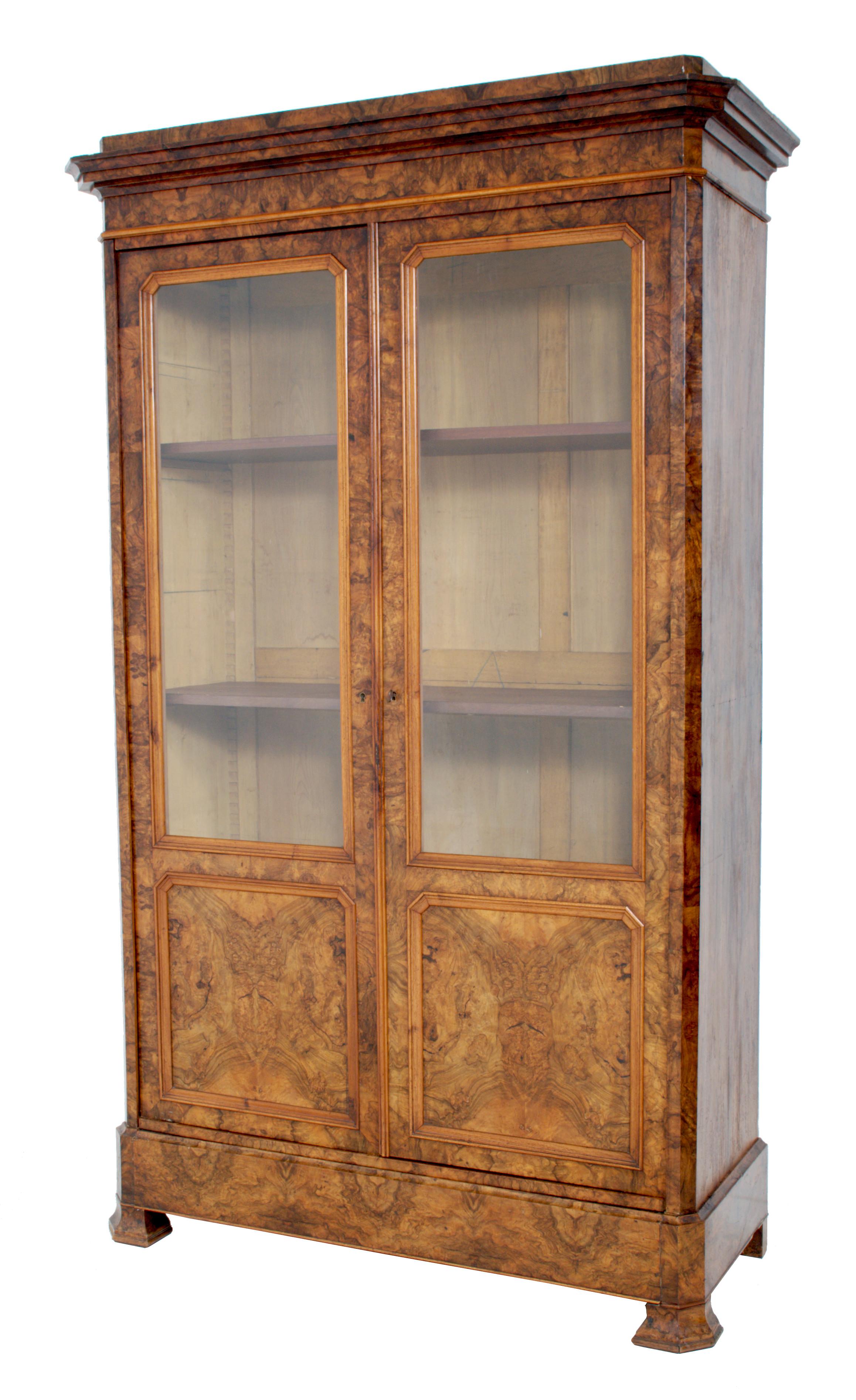 Antique French Louis Philippe burl walnut bookcase / cabinet, circa 1830. The bookcase having a stepped cornice with two doors below enclosing three adjustable shelves. The bookcase having a 'secret' drawer to the base, raised on bracket feet, and