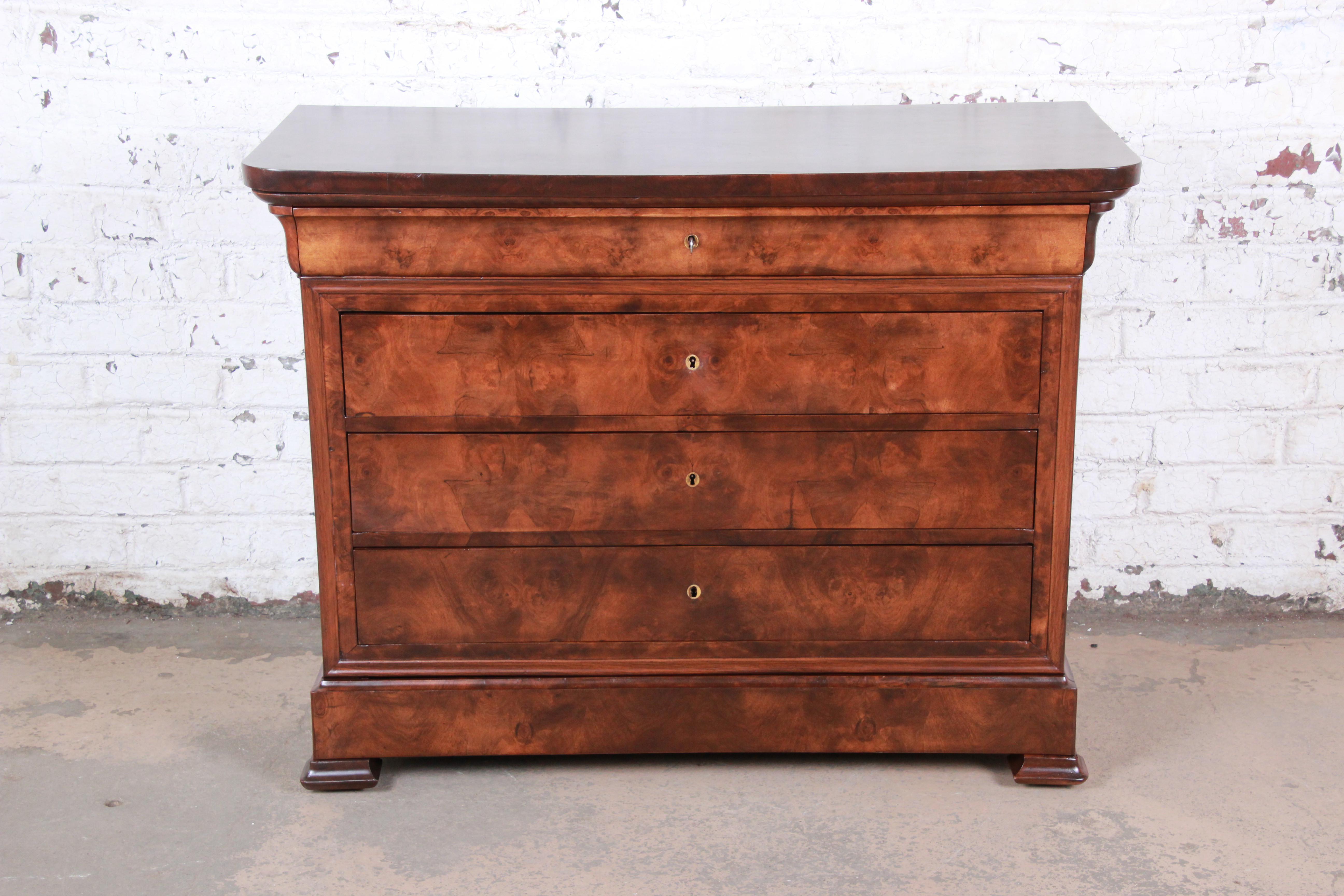 An exceptional French Louis Philippe burled walnut chest of drawers or commode, circa 1840. The dresser features stunning wood grain and elegant style. It offers good storage, with five dovetailed drawers. The top four drawers have locks, and the
