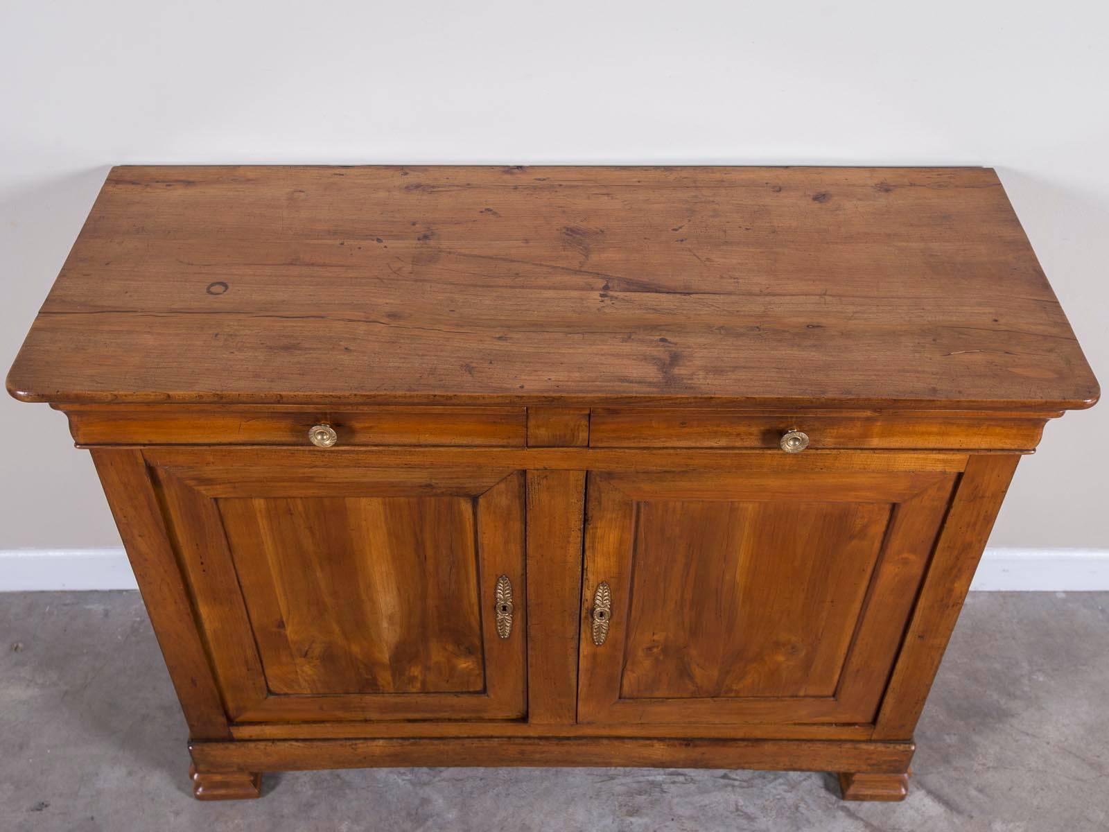 Bold timber, luscious color, modern silhouette. This antique French Louis Philippe cherrywood credenza buffet, circa 1850, has all the hallmarks of a cabinet perfectly suited for a modern interior. The handsome simplicity of this antique French