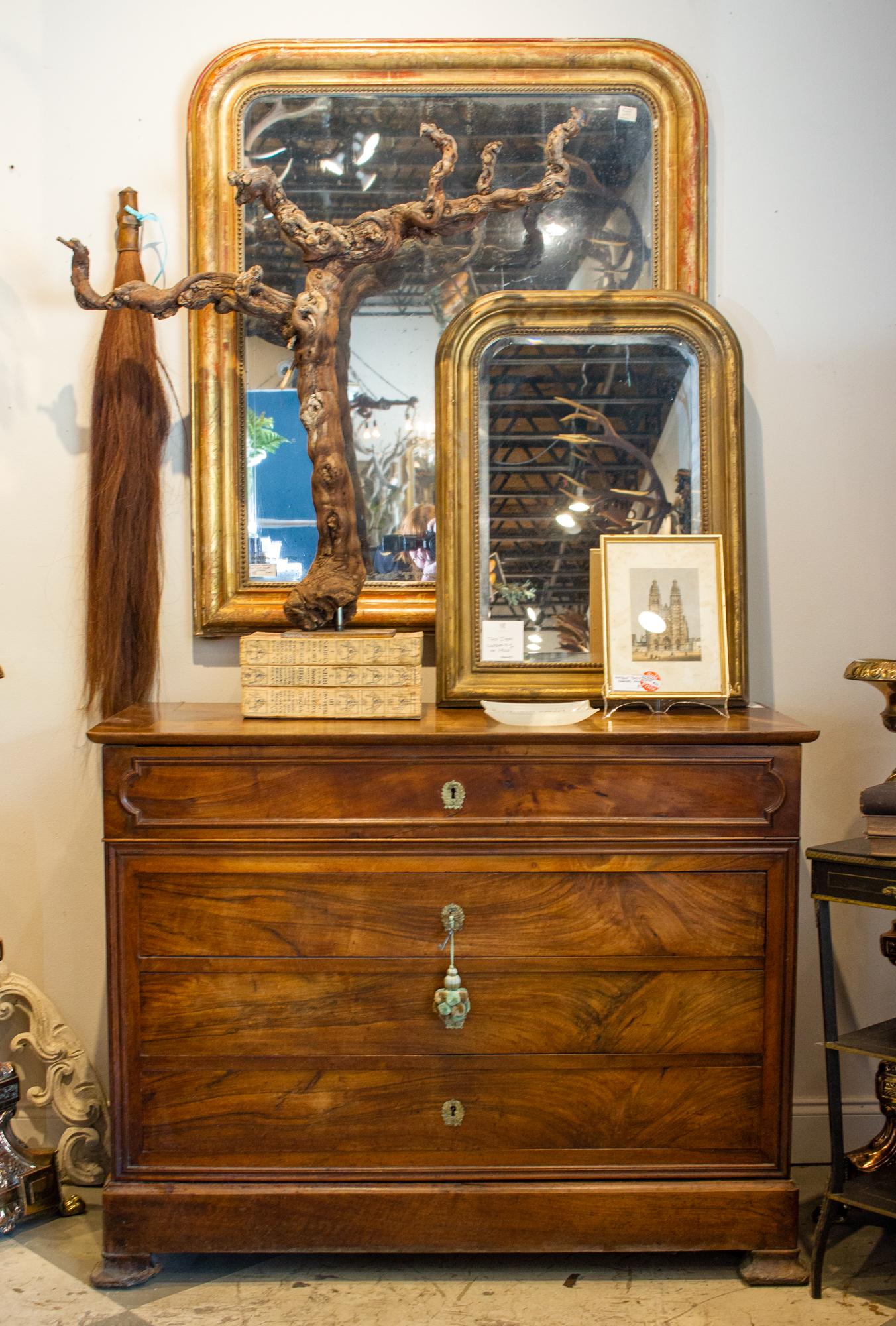 This antique French mahogany commode has many features that give it a Louis Philippe style, including the drawer design, which includes three main body drawers, along with a top drawer with a built-in bureau. There's also a narrow bottom drawer