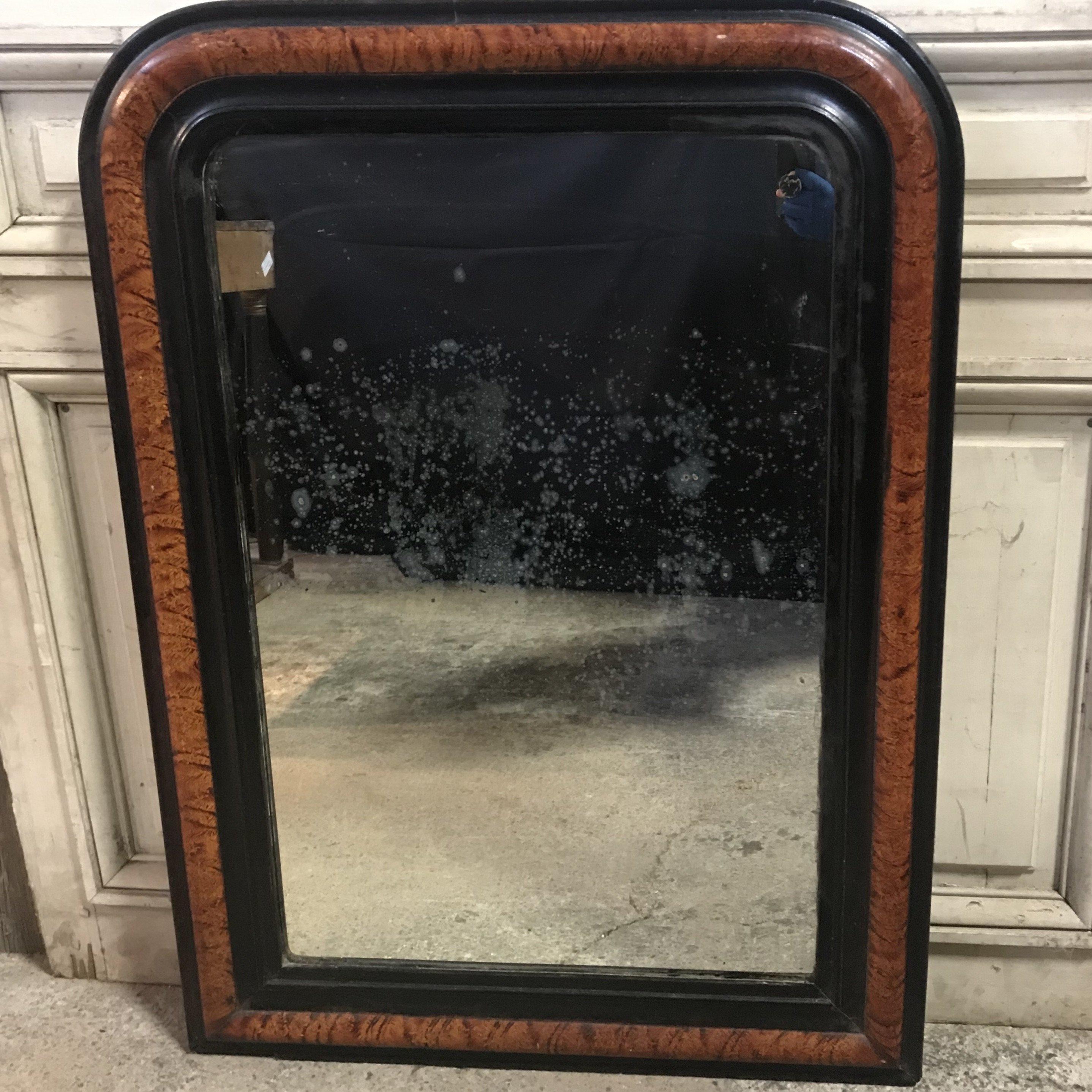 Late 19th century Louis Philippe mirror having beautiful faux bois painted finish on the frame which looks like wood grain, in a rich brown tone rimmed with ebony. The mirror itself shows age with some spotting, which speaks to the age of the piece,