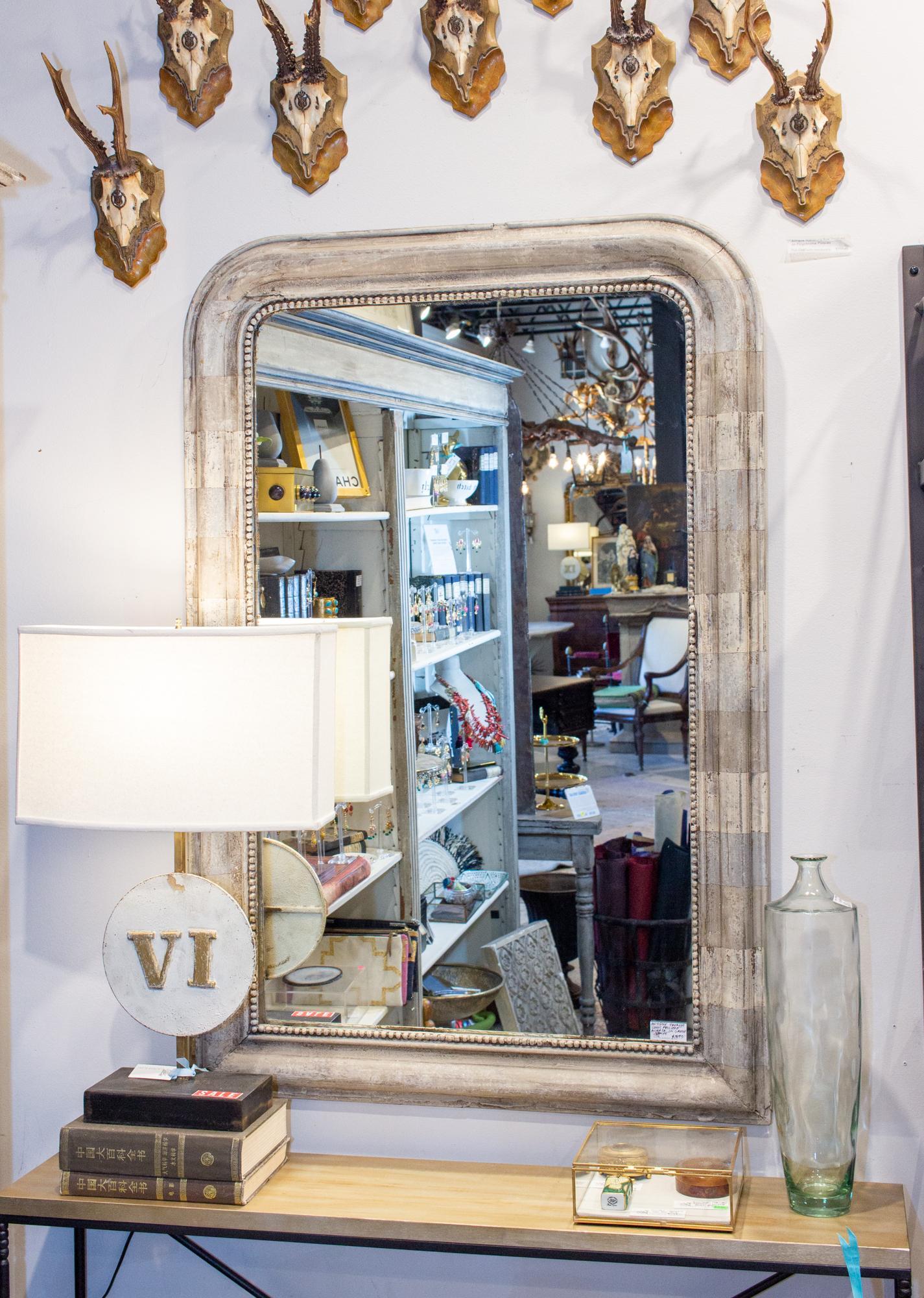 This antique French Louis Philippe mirror came to us with a very distressed gilt finish. We had it refinished in a hand painted greige stripe in various tones-- blue-gray, white and Classic greige. The tones are very similar, which gives the piece a
