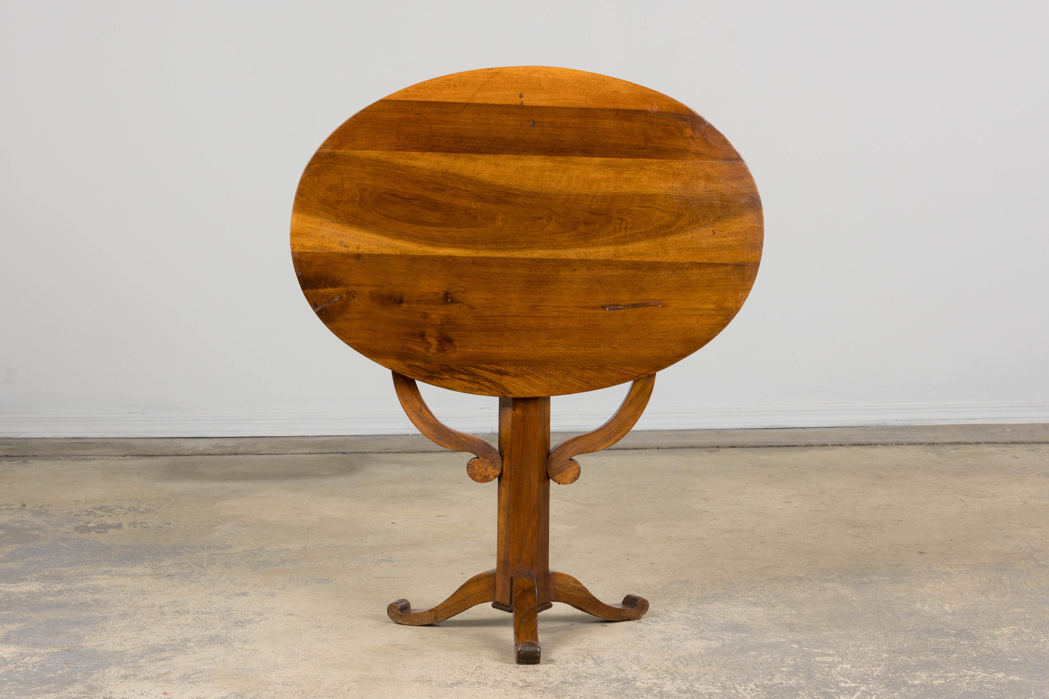 An elegant late 19th-century country French provincial vendange (wine tasting) table made in Louis Philippe style, sourced from Provence, France. Beautifully hand-crafted from solid walnut, it features a distinctive oval tilt-top. The surface has