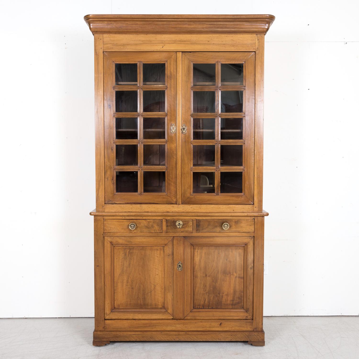 A mid-19th century French Louis Philippe period buffet à deux corps or bibliothèque handcrafted of walnut by talented artisans near the city of Arles, a UNESCO World Heritage site because of its abundance of Roman and Romanesque architecture, circa