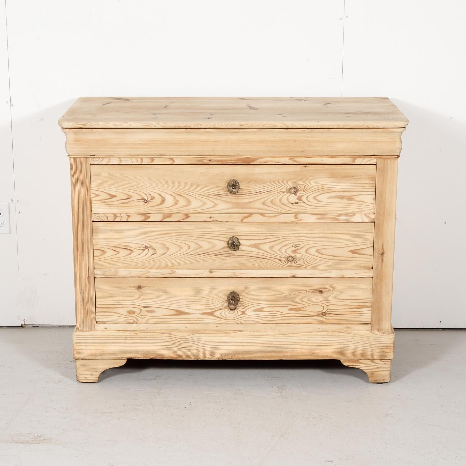 Antique French Louis Philippe style commode handcrafted of pine in the French Alps near Chamonix, circa 1890s. Sturdy and functional, this handsome bleached pine chest of drawers has a top doucine drawer and 3 full drawers below and the typical