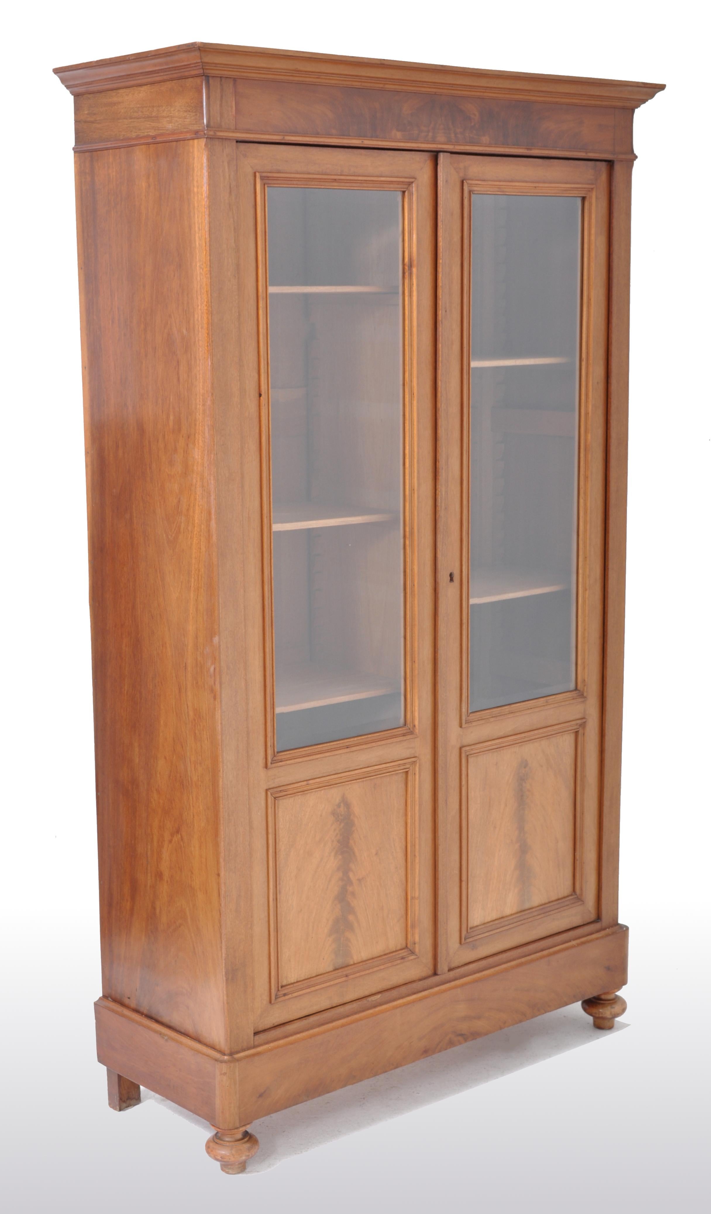 Antique French Louis Philippe walnut bookcase / cabinet / vitrine, circa 1850. The bookcase made from finely figured walnut throughout and having a stepped cornice to the top. Below are two doors, each with the original beveled glass and enclosing