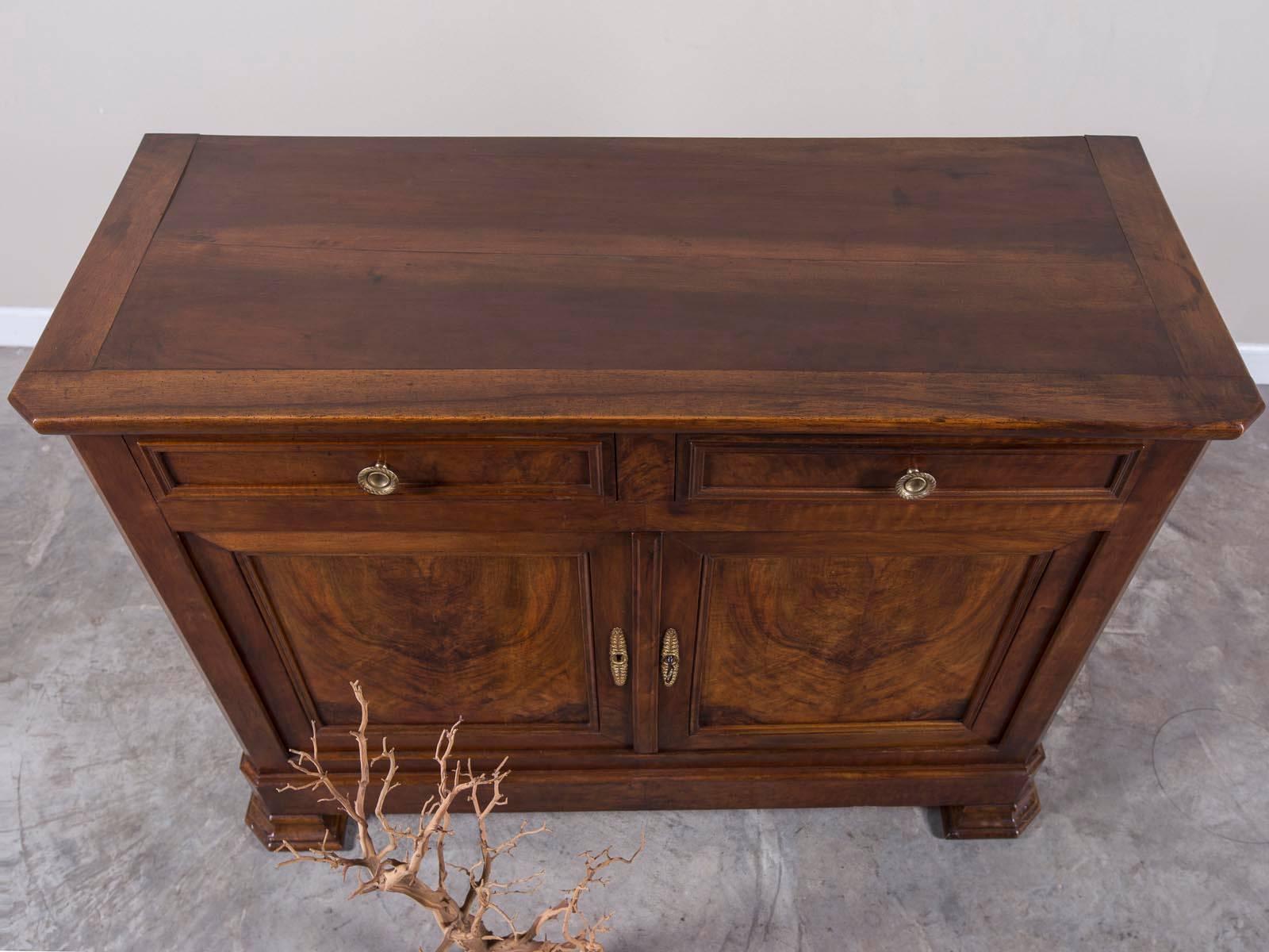 The striking walnut timber on this antique French Louis Philippe buffet circa 1850 remains as potent today as when it was first constructed. Concentrated on the cabinet doors and drawer fronts as well as the sides this timber was highly prized and