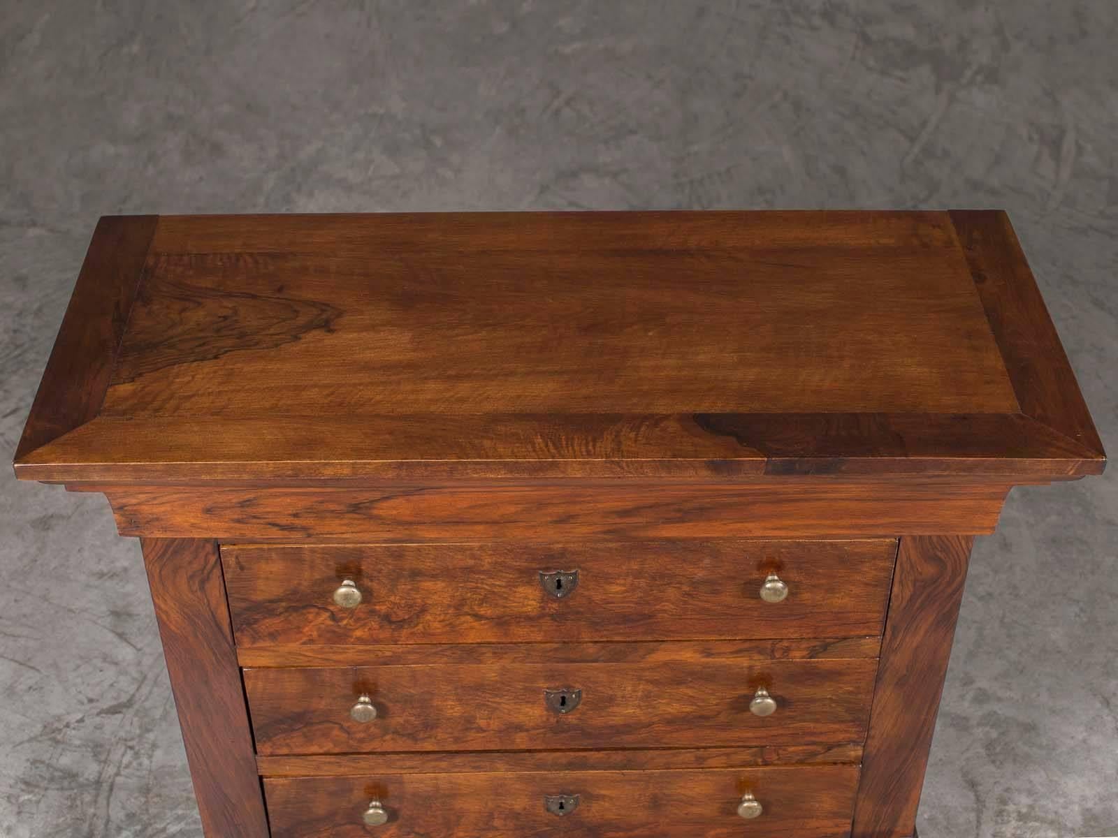 The smaller scale of this antique French Louis Philippe walnut chest of drawers or commode, circa 1870 makes it especially desirable as a bed side chest or for use beside a sofa. Designed during the reign of King Louis Philippe (1830-1848) in France