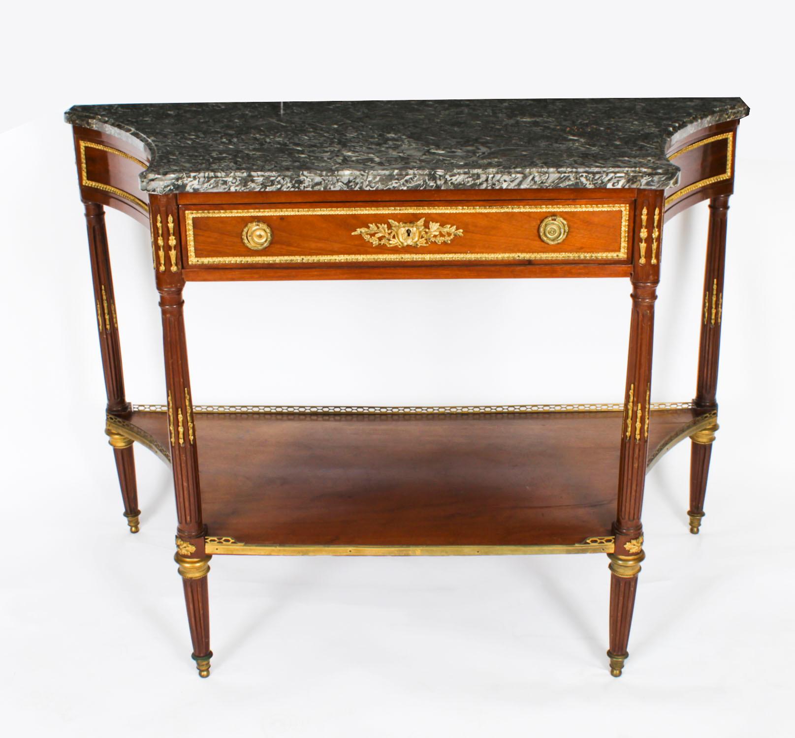 Il s'agit d'une belle table console ancienne en acajou, de style néo-louisianiste, avec un plateau en marbre et des ornements en bronze doré, datant de 1880.
 
Le plateau en marbre de Sainte-Anne des Pyrénées est orné d'une galerie décorative en