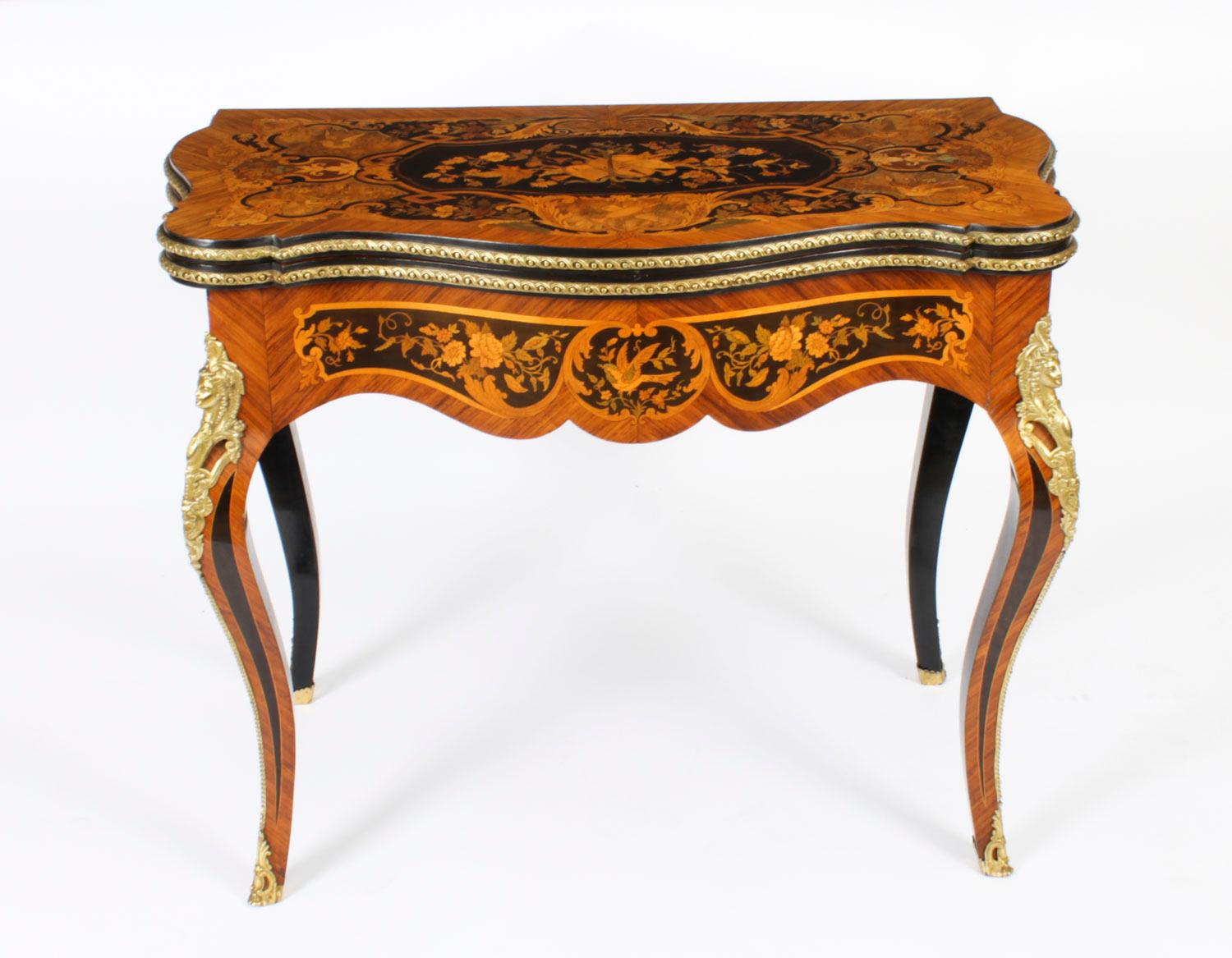Impresionante mesa de cartas rectangular con forma de marquetería floral y ormolina del Renacimiento Luis XV francés del siglo XIX, datada hacia 1870.
 
La parte superior perfilada tiene incrustaciones de marquetería en bandas que abarcan un