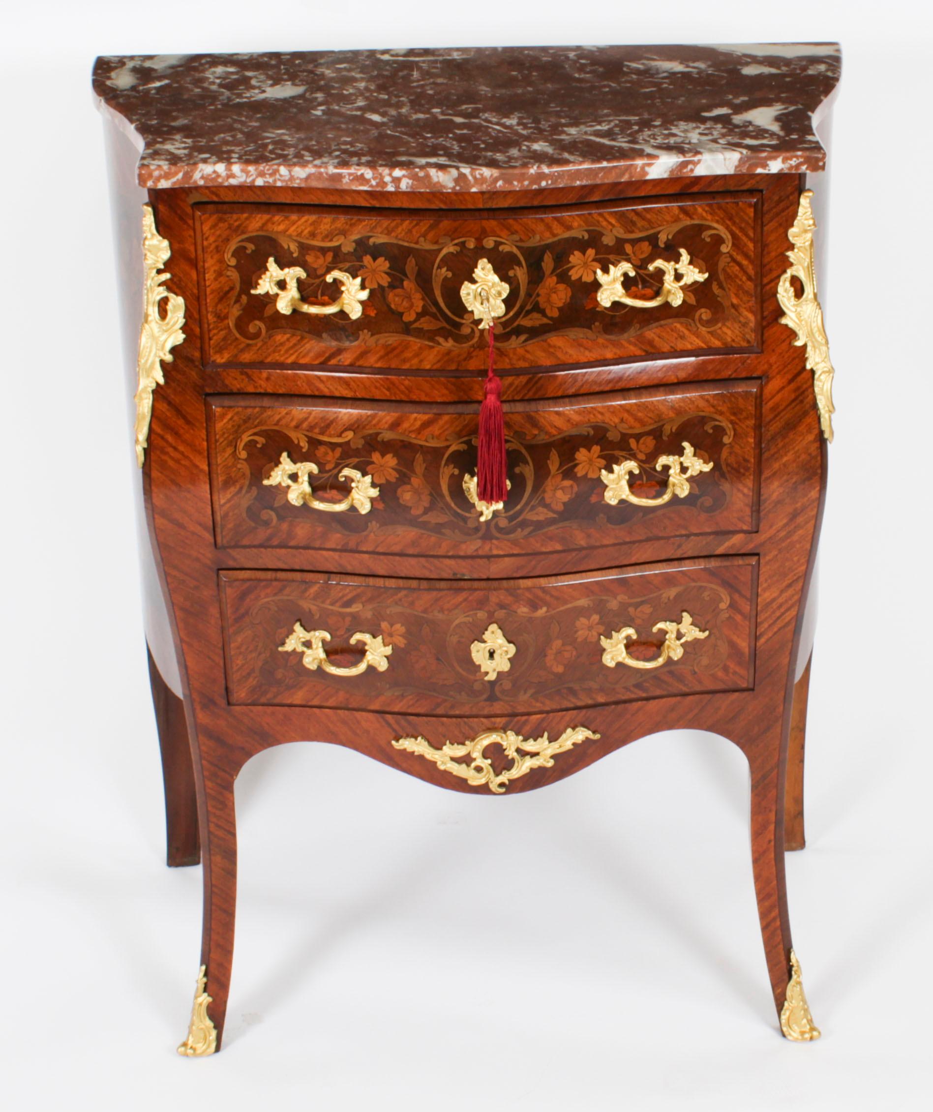 This is a stunning antique French walnut and marquetry Louis Revival bombe commode, circa 1880 in date. 
 
This gorgeous commode features a stunning shaped Rouge Griote marble top above three full width drawers for ample storage, and was inspired by