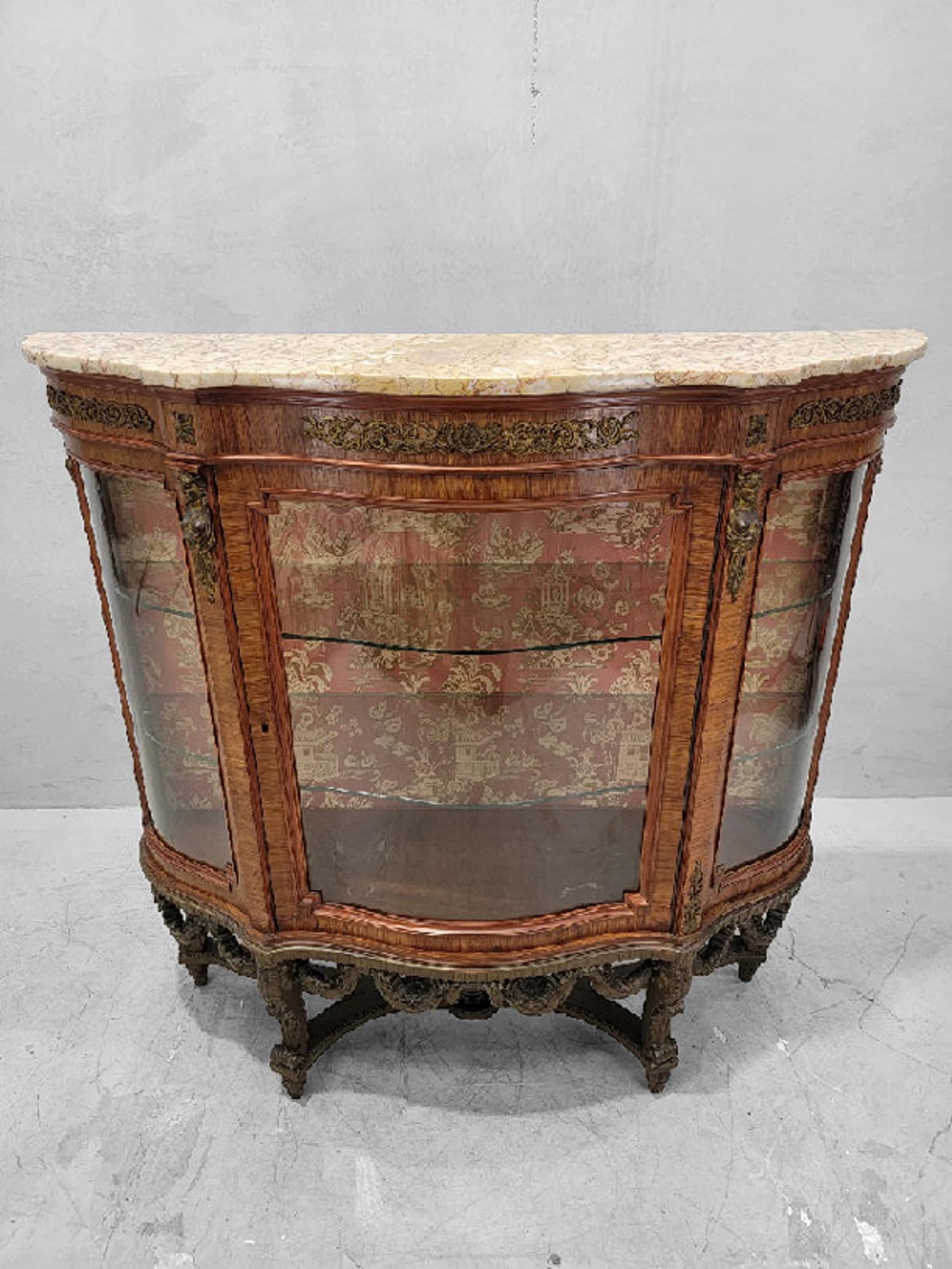 Antiker französischer Vitrinenschrank im Louis-Stil mit geschwungener Glas-Marmorplatte

Dieser exquisite antike französische Vitrinenschrank im Louis-Stil zeichnet sich durch ein wunderschön geschwungenes Glasdesign aus, das durch eine luxuriöse