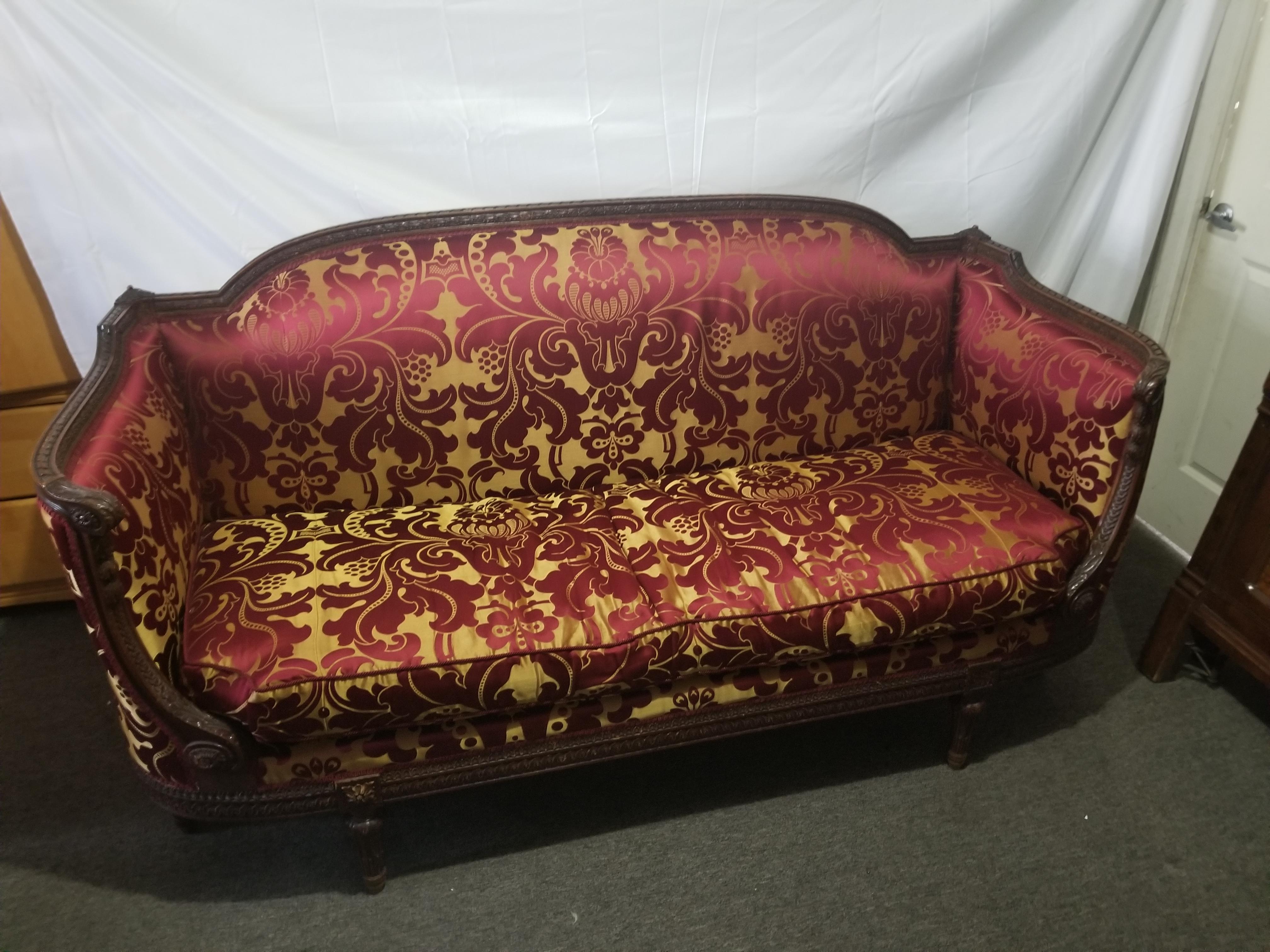 Antique French Louis XVI style carbed walnut frame sofa, circa 1860. The six Legget box form with swelled crest rail, two high inverted arms terminating in scrolled hand and styles with rosettes. Carved apron with guilloche bands, to six tapered