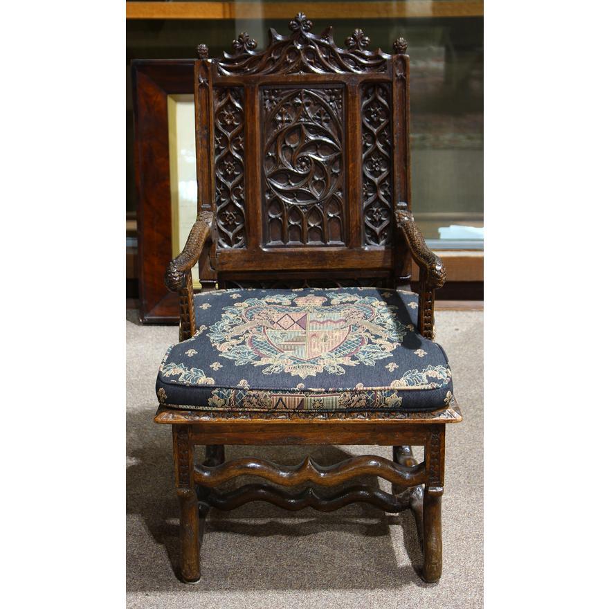 18th Century French Louis XIII style gothic carved oak armchair, the carved crest having trefoil accents, above the back decorated with quatrefoil panels, continuing to the scrolled arms accented with carved feathers, and rising on in swept feet