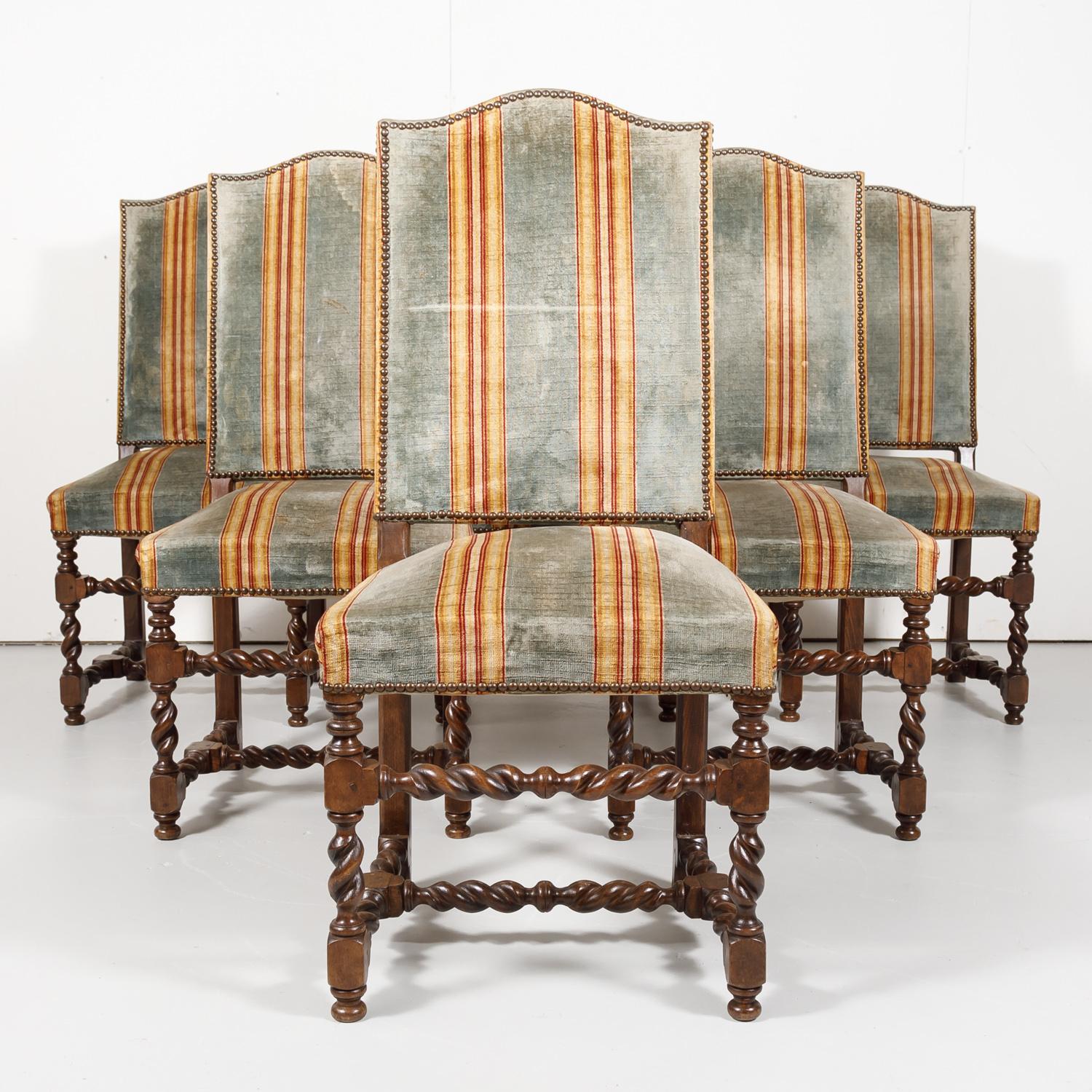 Set of six antique French Louis XIII style barley twist dining side chairs handcrafted and carved of French walnut in Lyon, having high chapeau de gendarme backs and nail head trim, circa 1890s. Raised on turned barley twist legs with barley twist
