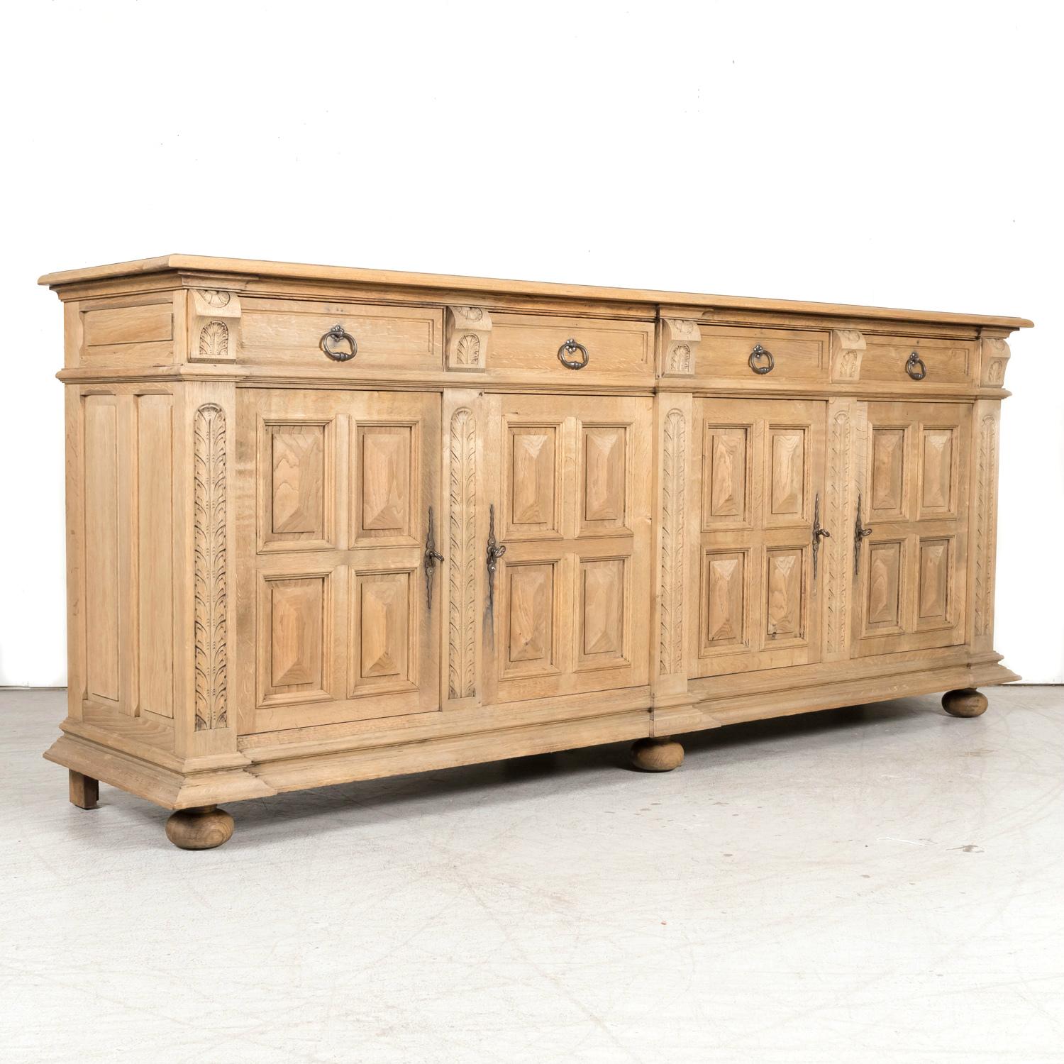 An antique French Louis XIII style carved enfilade buffet handcrafted of solid oak by talented atisans in the picturesque town of Honfleur, a commune in the Calvados department located on the Normandy coast on the southern bank of the estuary where