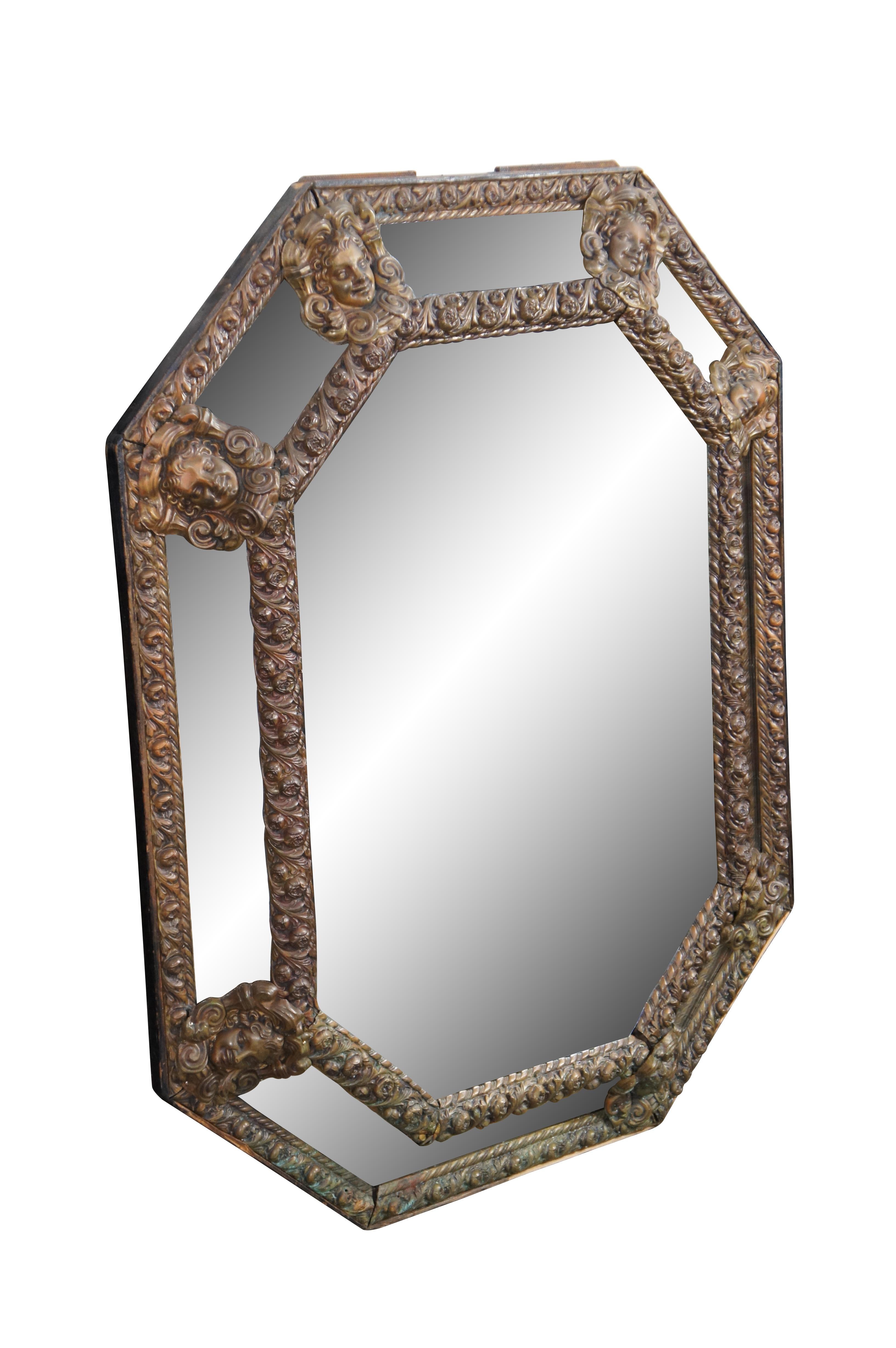 Miroir octogonal ancien de style Louis XIII, orné d'un repoussé de laiton figuratif mettant en valeur des roses et des visages de chérubins.  Idéal pour une utilisation le long d'un mur ou au-dessus d'une cheminée.   

Dimensions :
32.5