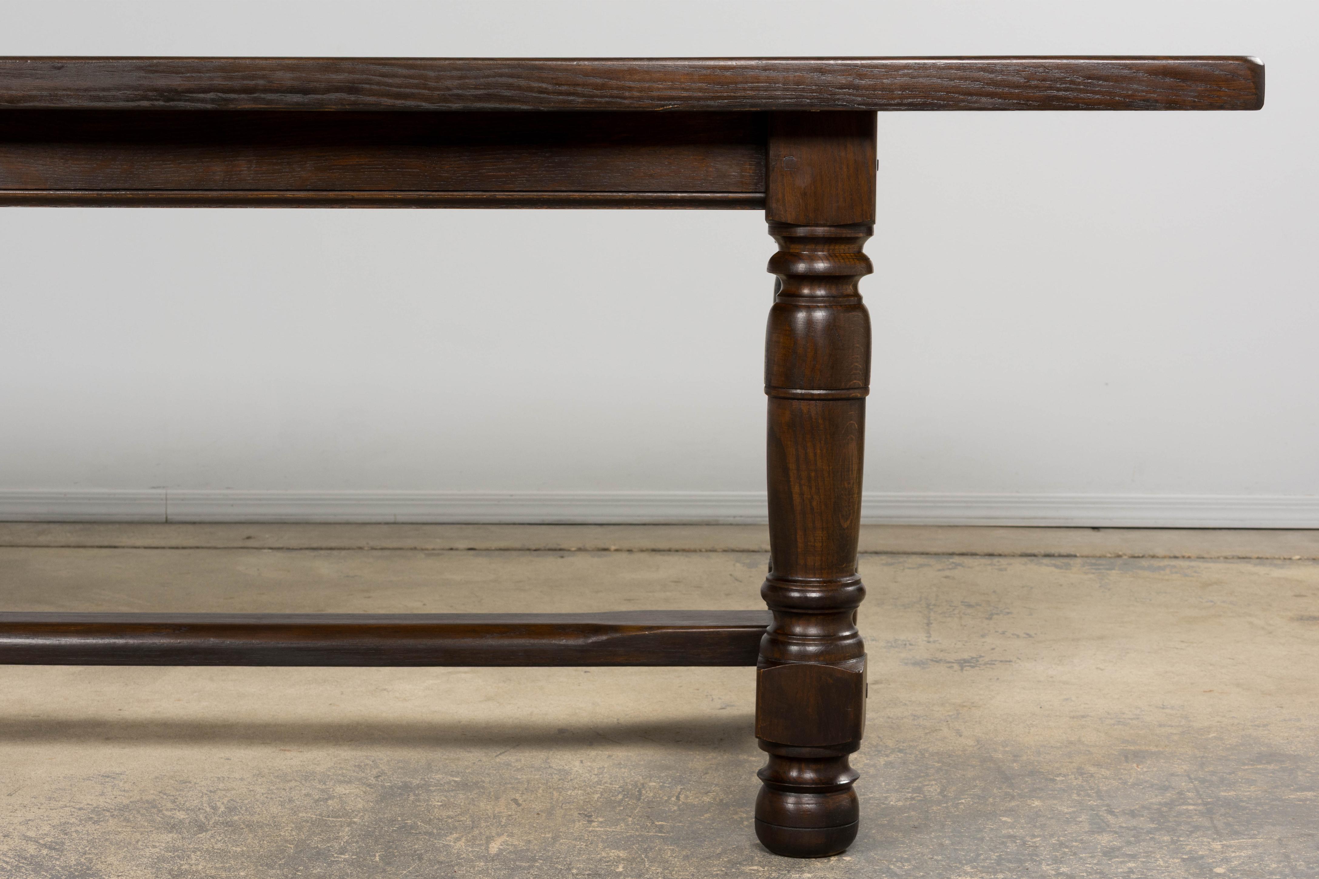 Une table de salle à manger ancienne de style Louis XIII, provenant de Provence, France. Fabriquée en chêne massif, la table présente un épais plateau rectangulaire de 2 pouces reposant sur des pieds balustres audacieusement tournés, unis par un