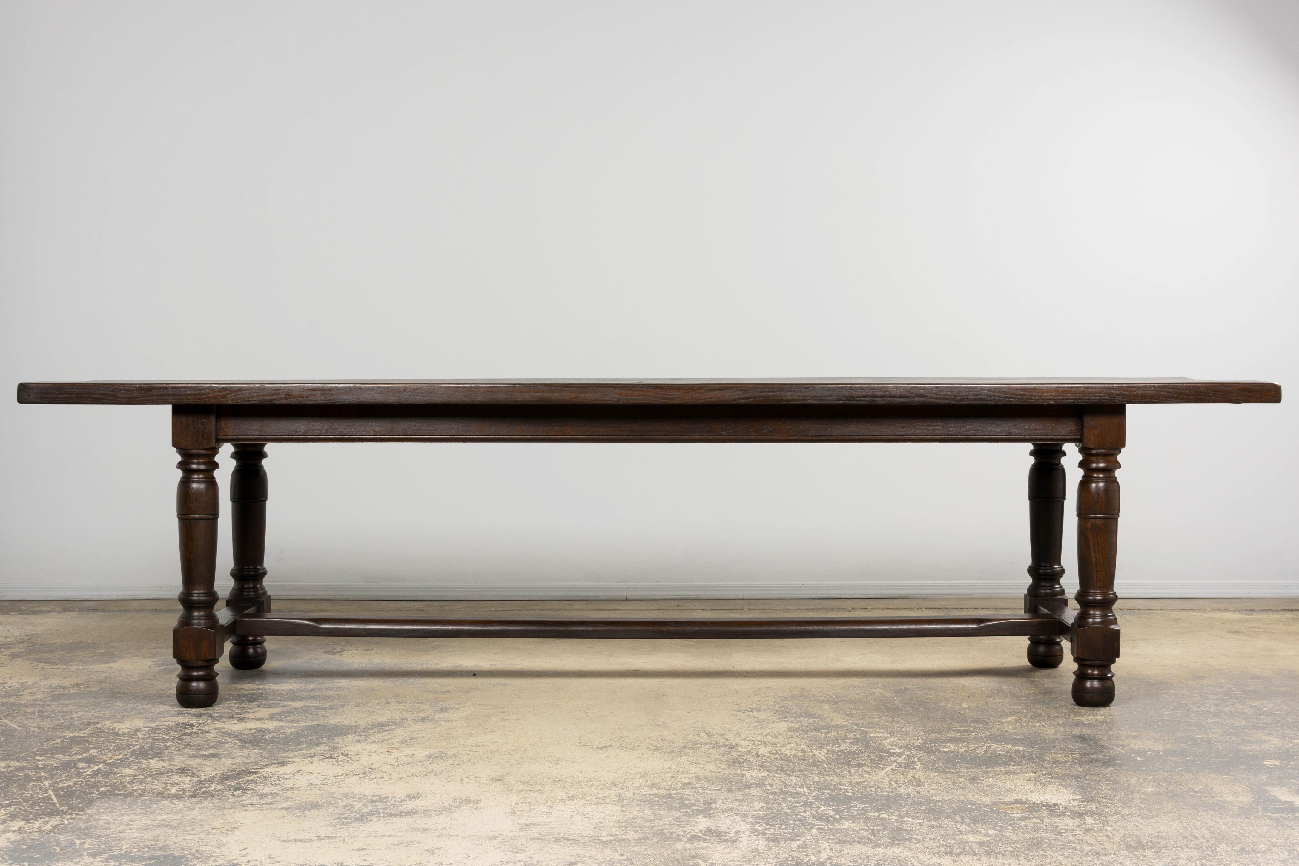 Un sostanzioso tavolo da pranzo antico francese in stile Luigi XIII, proveniente dalla Provenza, in Francia. Realizzato in rovere massiccio, il tavolo presenta un piano rettangolare spesso 2 pollici che poggia su gambe a balaustro audacemente