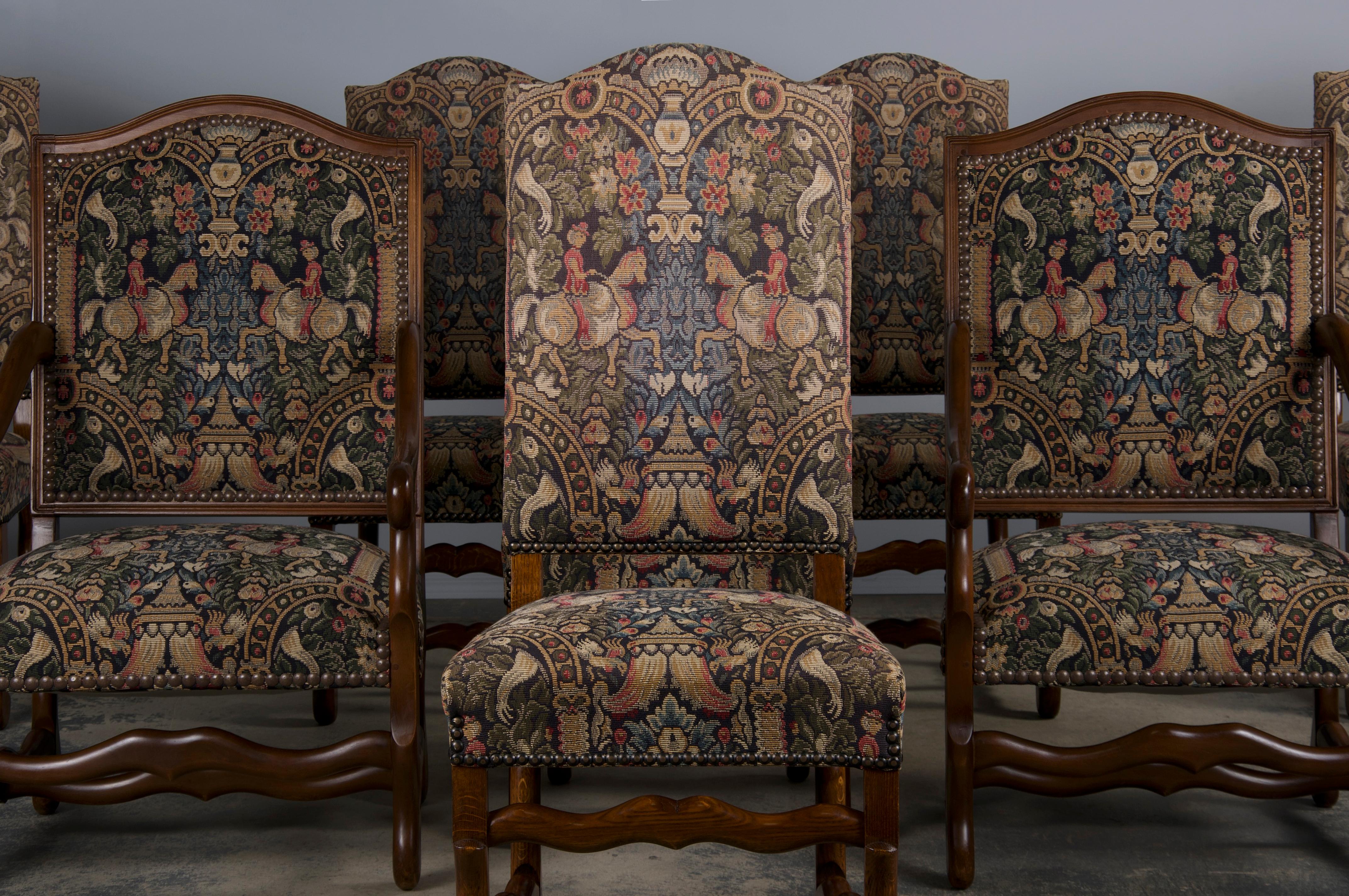 An exquisite set of eight French dining chairs in the style of Louis XIII, sourced directly from Provence, France. This set includes six side chairs and two throne-style armchairs, all masterfully hand-crafted from solid oak. The elegant design
