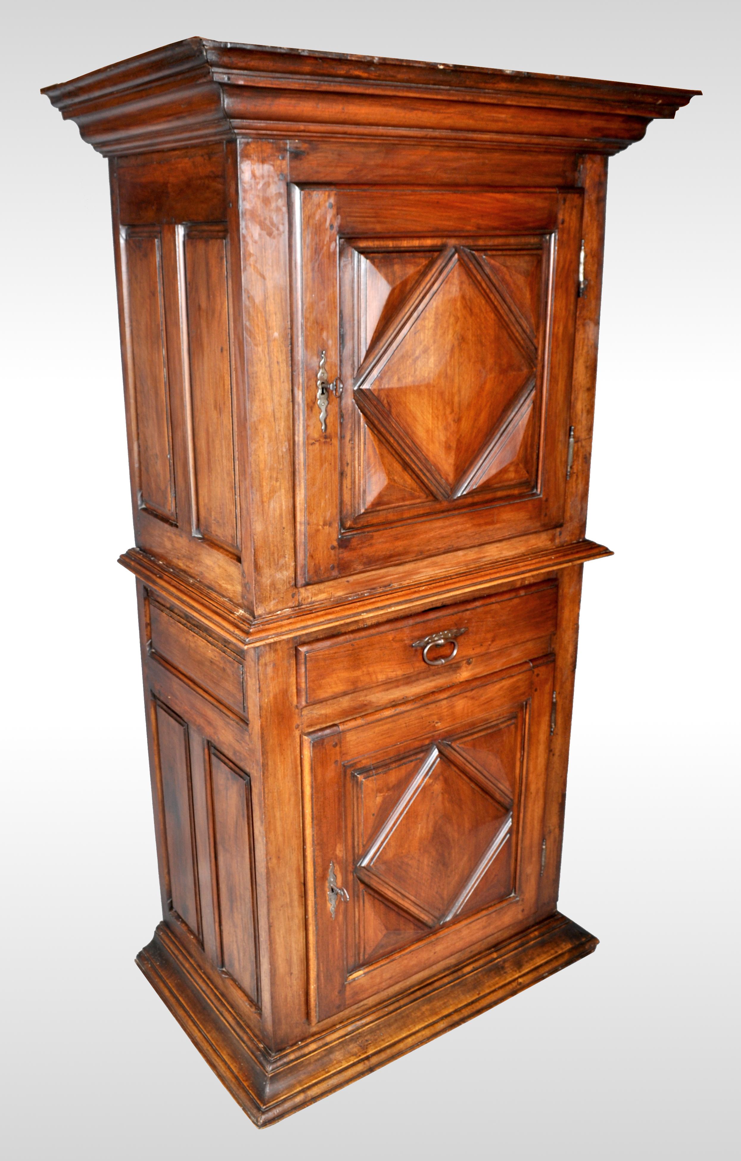 Antique French Louis XIII walnut cabinet / armoire / Bonnetiere, circa 1750. This large antique Bonnetiere from the Perigord region of France and having a stepped cornice with a single door below decorated with a deeply carved lozenge shape. The