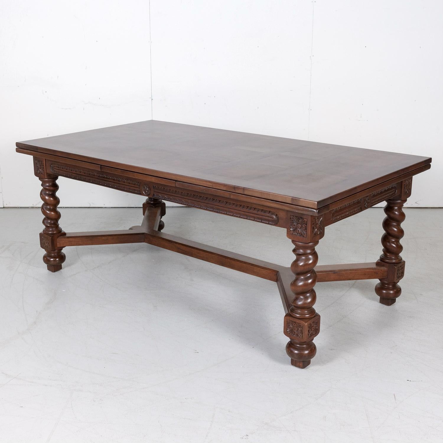 Antique French draw leaf or refectory table handcrafted of walnut near Lyon, circa 1920s, having a parquet top with draw leaves sitting above a carved apron. The leaves pull out in an instant when needed, then just as quickly tuck back in to reclaim