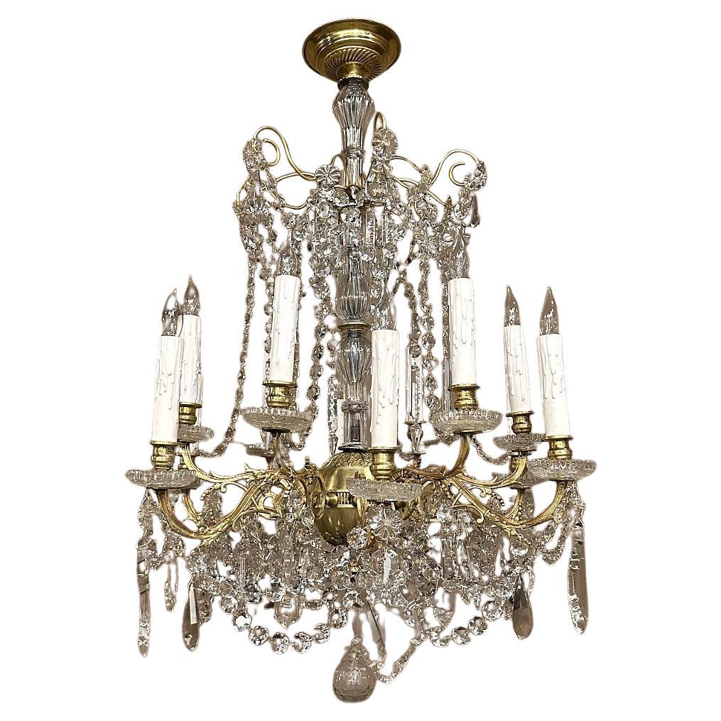 Le lustre Louis XIV en laiton et cristal fera scintiller toute pièce avec opulence !  Fabriqué en laiton finement repoussé et moulé, il présente un corps au design complexe qui comprend des feuillages naturalistes sur les bras élégamment enroulés. 