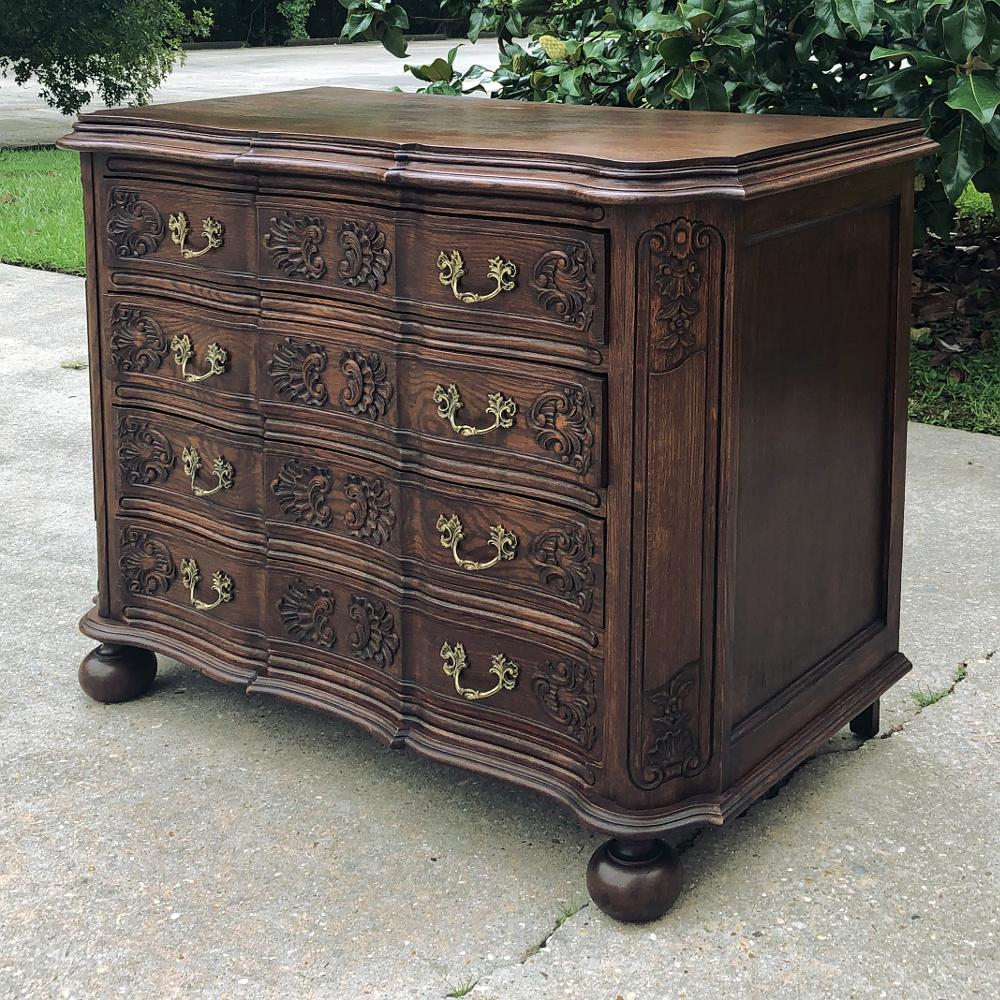 Antique French Louis XIV commode or chest of drawers is a study in the French masculine form, rendered from oak to last for generations! The contoured facade is framed by cornerposts that are curved back in a serpentine form and carved with stylized