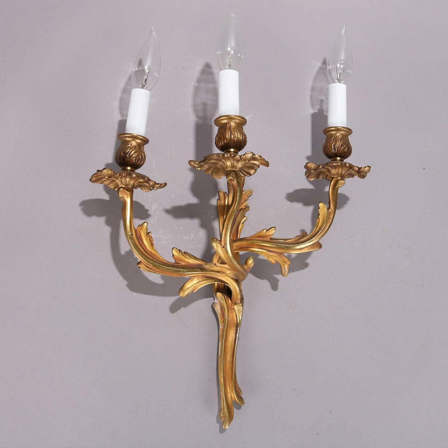 Pair of gilt bronze French Louis XIV electrified wall sconces feature foliate form each with three candle lights, newly re-wired, 19th century.

Measures: 20