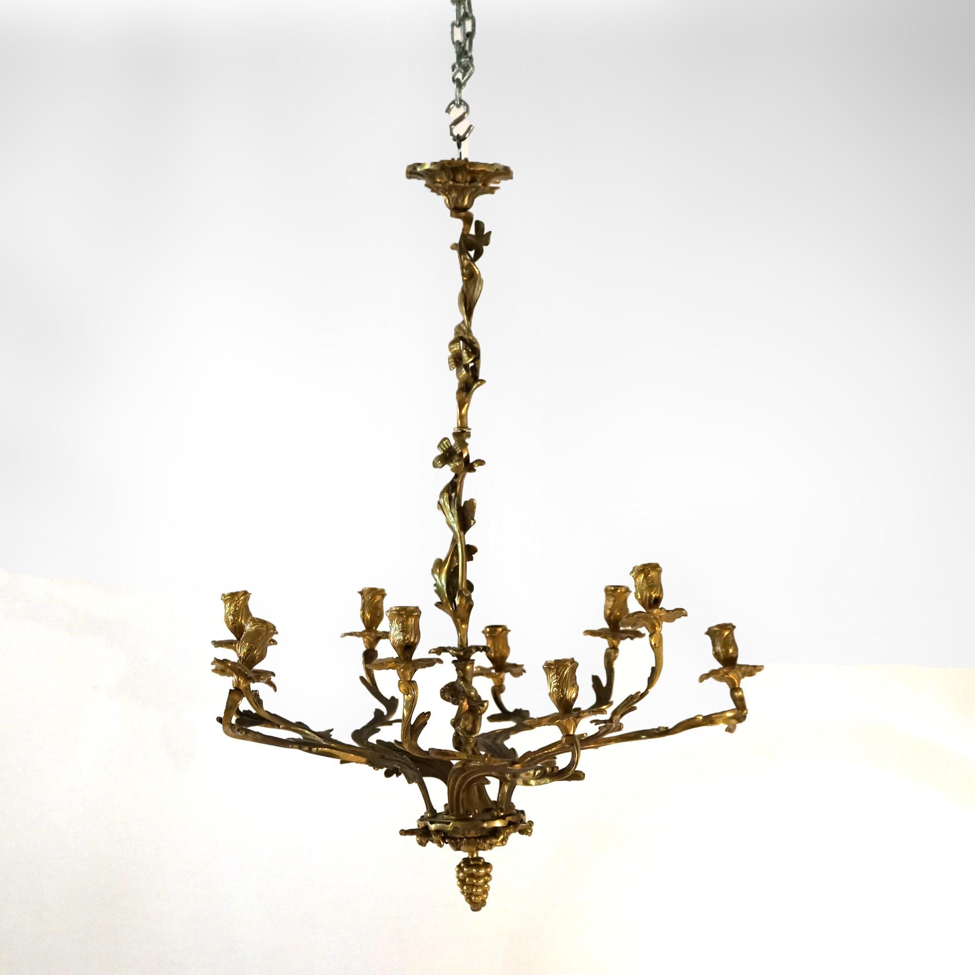 Ein antiker französischer Hängeleuchter im Louis-XIV-Stil bietet eine vergoldete Bronzekonstruktion mit einer Mittelsäule, die einen Cherub, eine Traube in Form eines tropfenförmigen Abschlusses und zehn blattförmige Arme hat, die in Kerzenfassungen