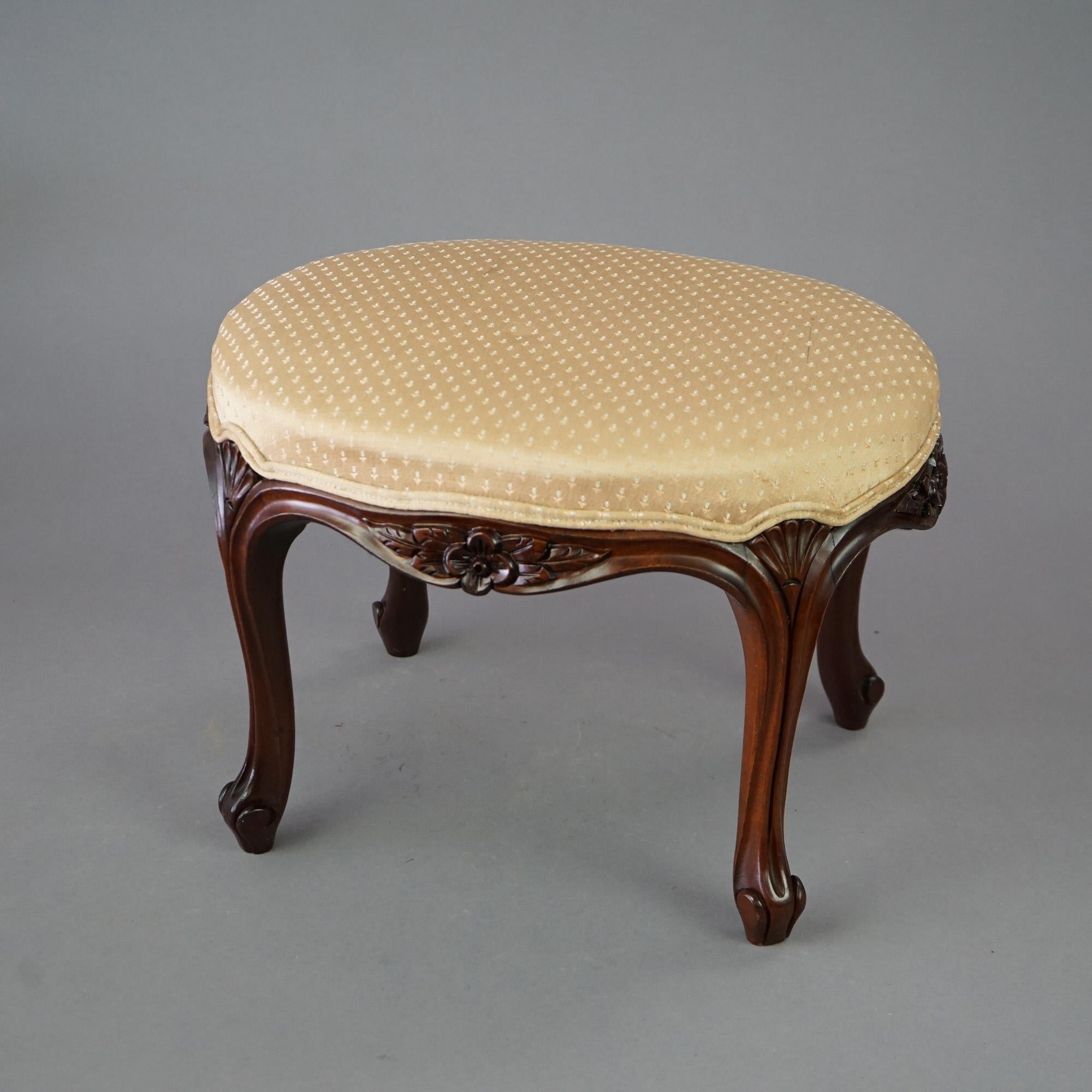 An antique French Louis XIV footstool offers upholstered seat in oval form with floral carved frame having cabriole legs, c1900

Measures- 14''H x 20''W x 15.75''D.
