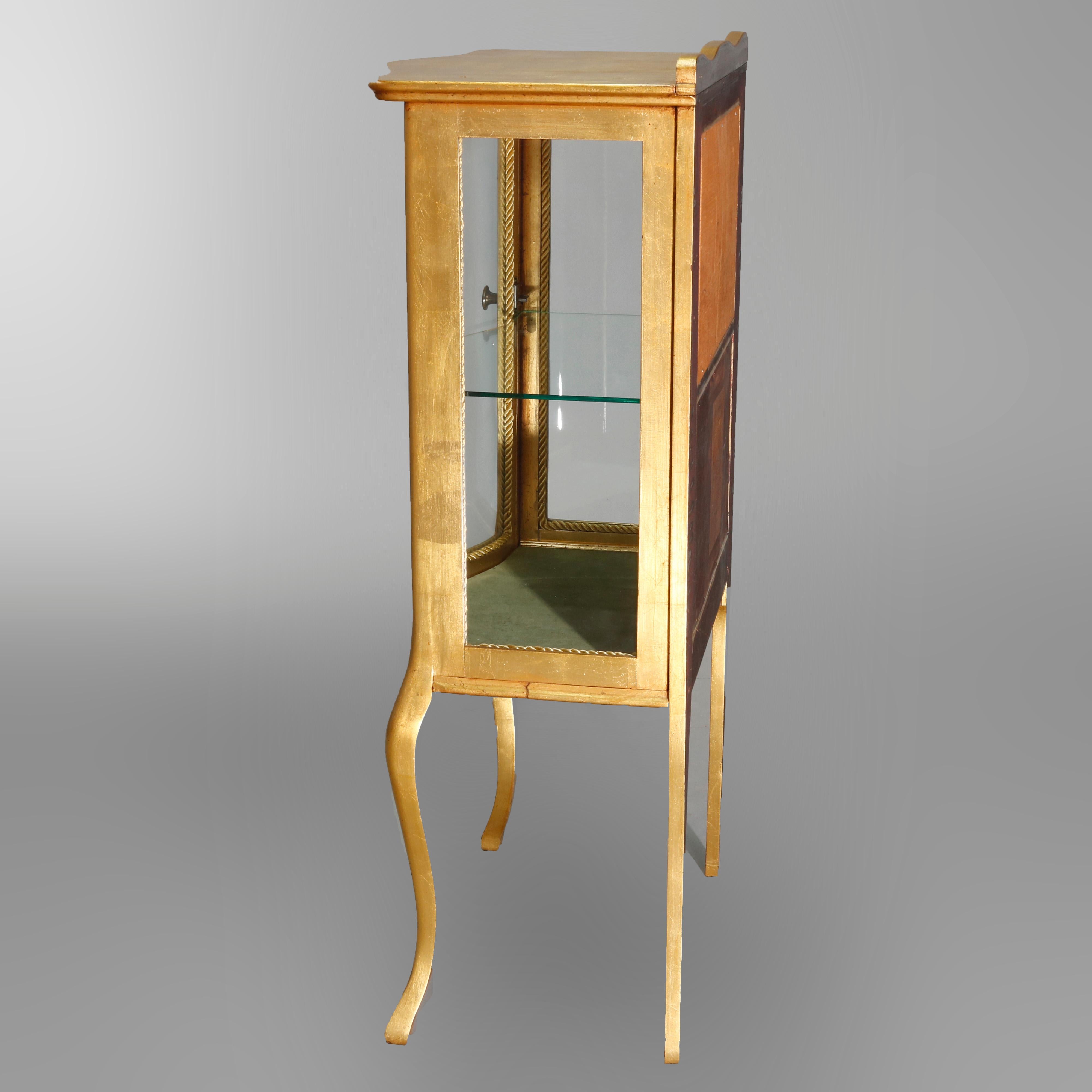 An antique French Louis XIV serpentine display vitrine offers giltwood construction with shaped backsplash surmounting bowed glass door opening to shelved and mirrored interior, raised on cabriole legs, circa 1910

Measures: 43.5