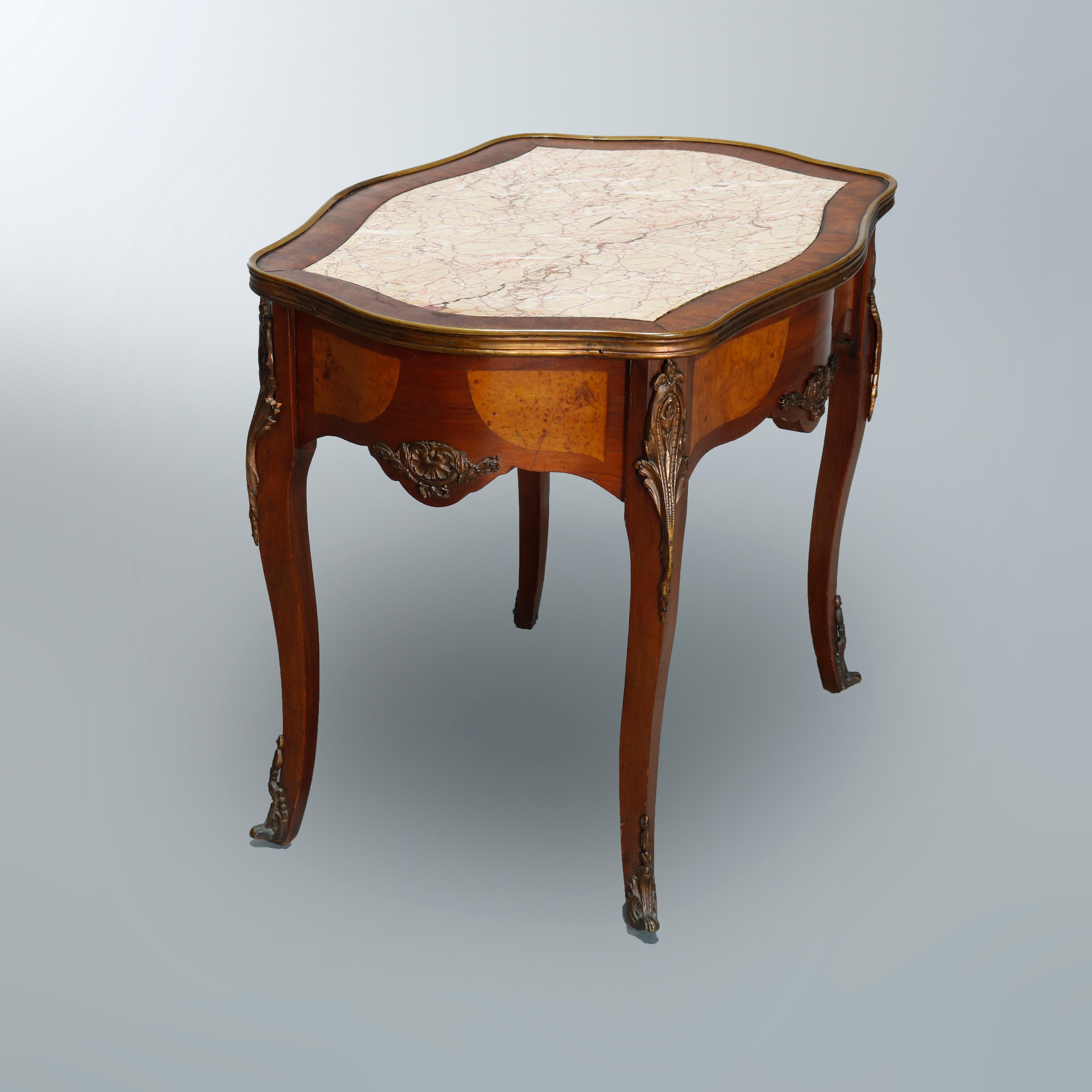 An antique French Louis XIV side table offers satinwood construction with shaped top having inset marble top with crossbanded picture frame border surmounting serpentine skirt with burl inlay reserves and foliate cast ormolu mounts, raised on
