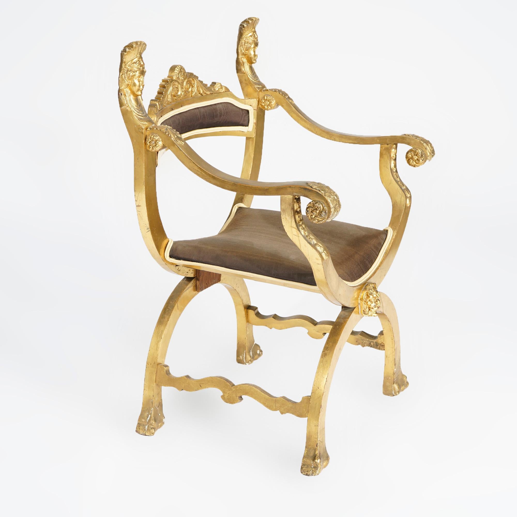 An antique French Louis XIV style figural curule throne chair offers giltwood construction with carved crest having flanking Queen masks, acanthus scroll form arms and satyr medallion below seat, 19th century

Measures- 36'' H x 24'' W x 21.5''