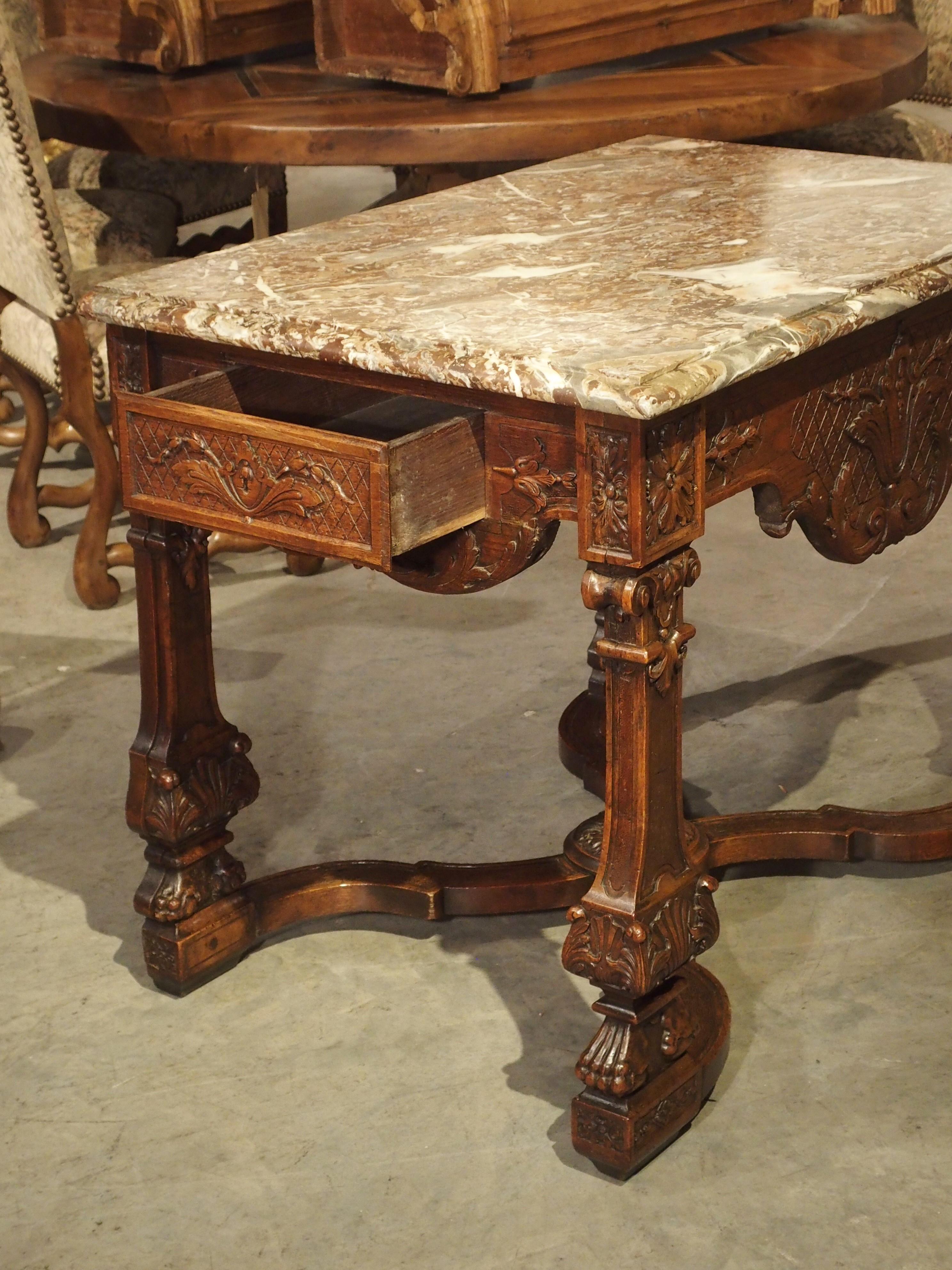 Dieser erstaunlich detailreiche Wildtisch aus Eiche und Marmor stammt aus Frankreich (um 1870) und wurde im Louis XIV.-Stil hergestellt. Obwohl der Tisch Ende des 19. Jahrhunderts entstanden ist, enthält er Elemente, die noch älter sind als