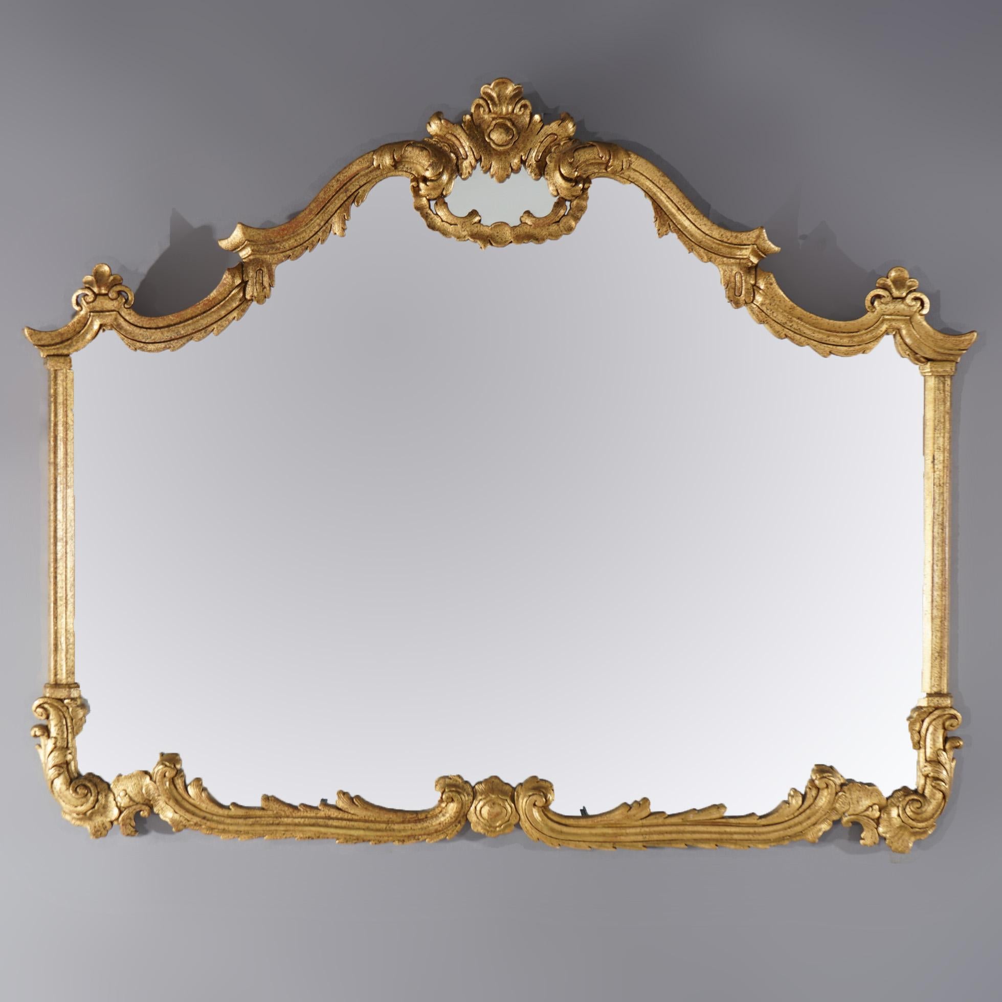 An antique French Louis XIV style over mantel mirror offers scroll and foliate form giltwood frame having stylized floral crest and flanking finials, c1920

Measures - 38