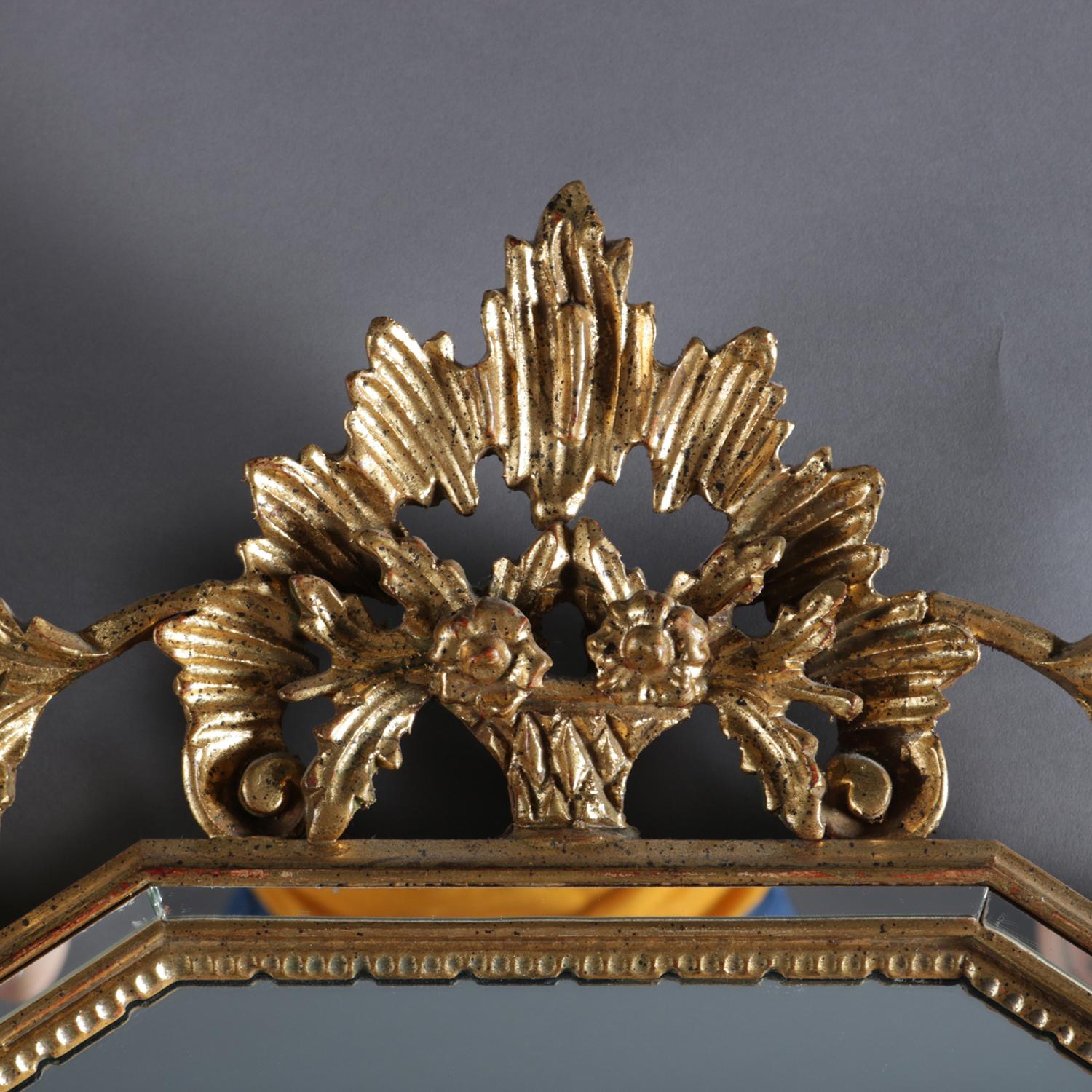 Antique French Louis XIV style parclose wall mirror features giltwood frame with pierced corbeille a fleurs (basket of flowers) crest with flanking foliate and floral form surround decoration, mirror with narrow paneled border, and base with scroll