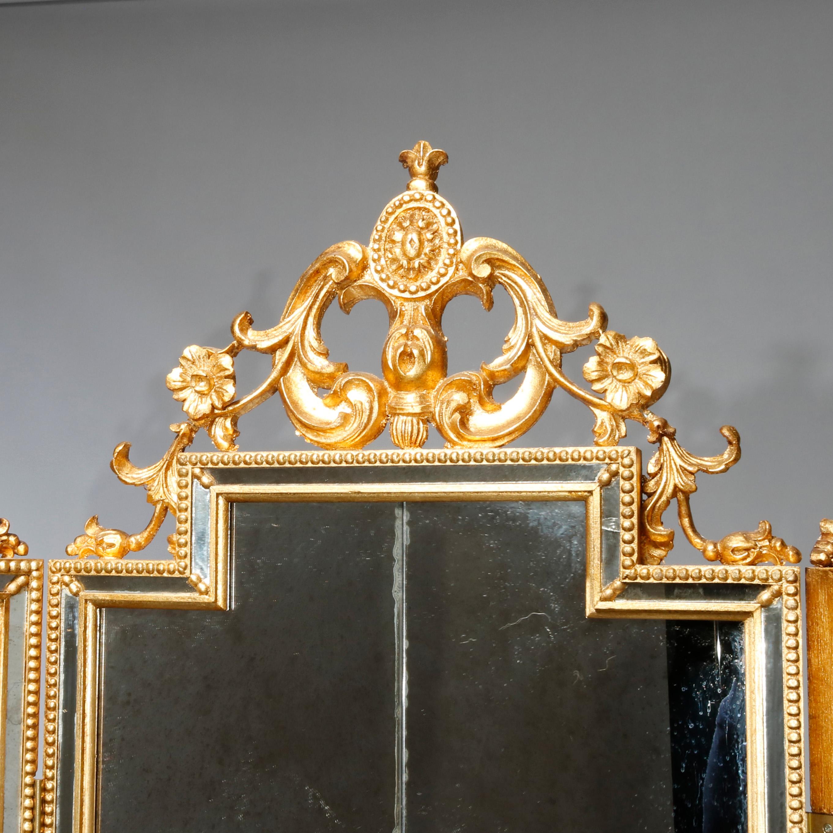 An antique French Louis XIV style dressing screen by LaBarge offers a carved and pierced giltwood frame with crest having central medallion and flanking scroll and foliate elements over paneled mirror glass section having beaded trim, original label