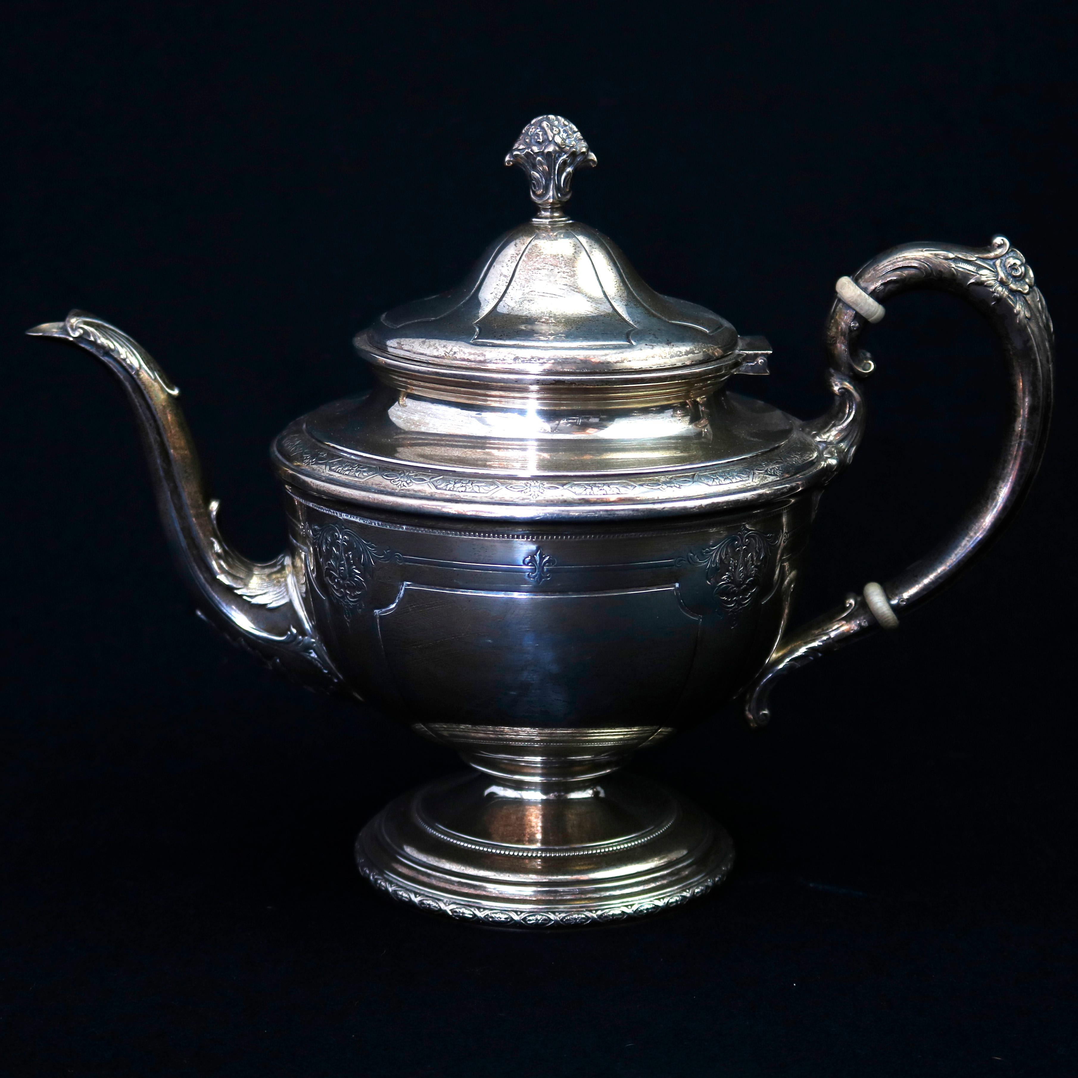 An antique French Louis XIV sterling silver tea set by Tole offers four pieces with panier de fleurs form finials surmounting vessels with embossed and engraved foliate elements and Fleur de Lis with foliate form handles with insulators and raised