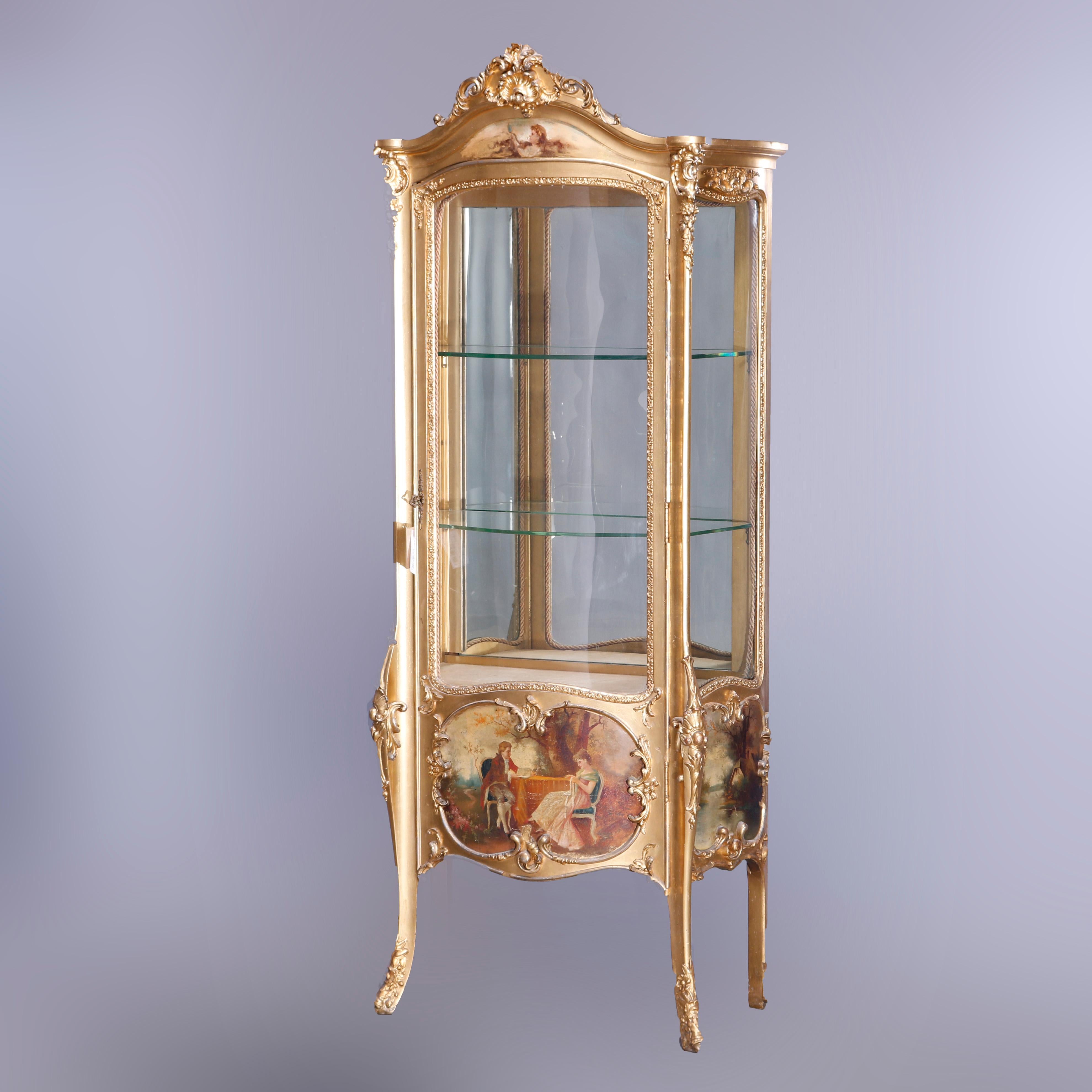 An antique French Louis XIV style vitrine offers giltwood construction with shaped crest having central shell with flanking foliate elements and surmounting case with single curved glass door opening to shelved mirror-back interior over Vernis