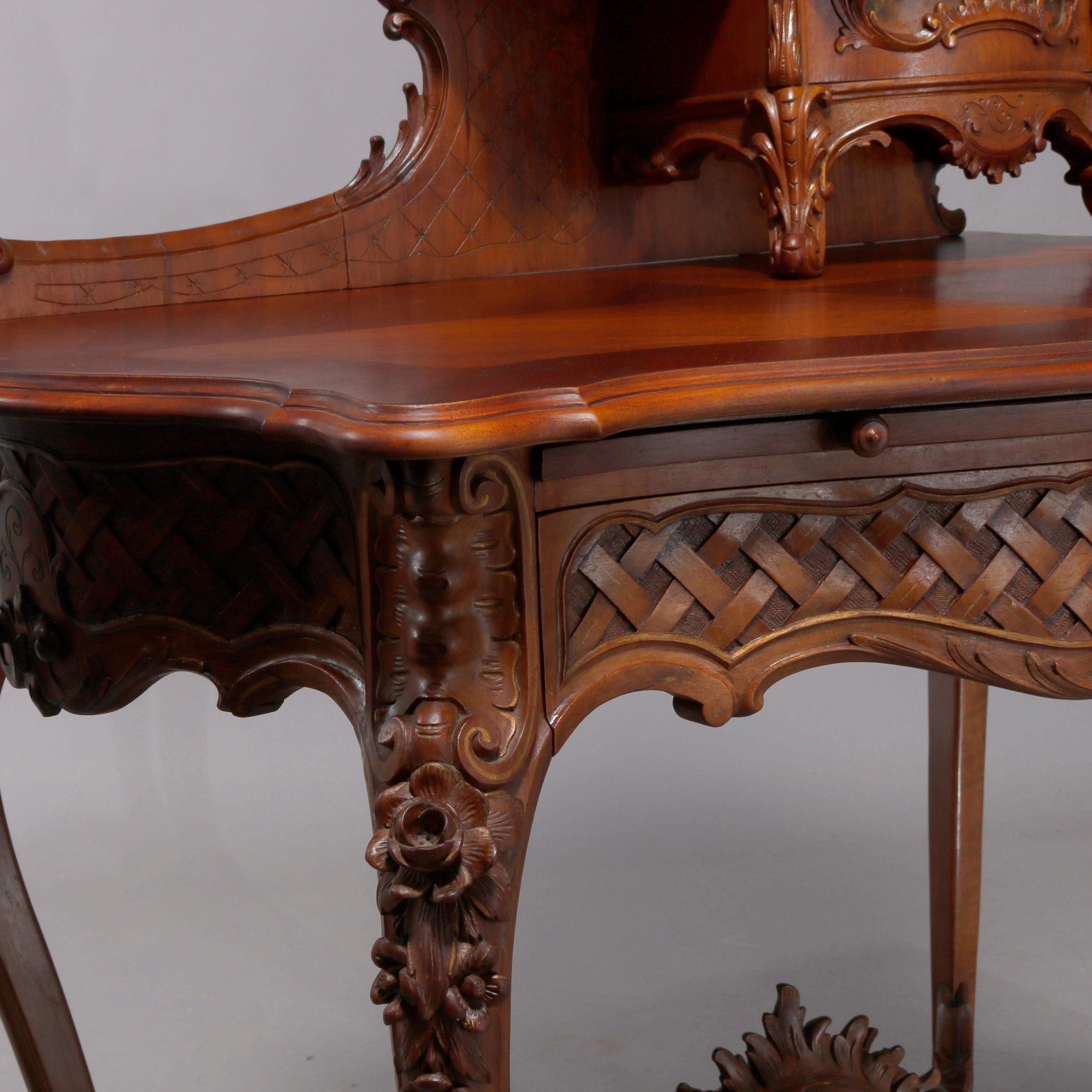 An antique French Louis XIV ladies desk offers mahogany and kingwood construction with tower cabinet having carved gadroon cartouche over single door with Vernis Martin painted courting scene opening to shelved interior and having side display shelf
