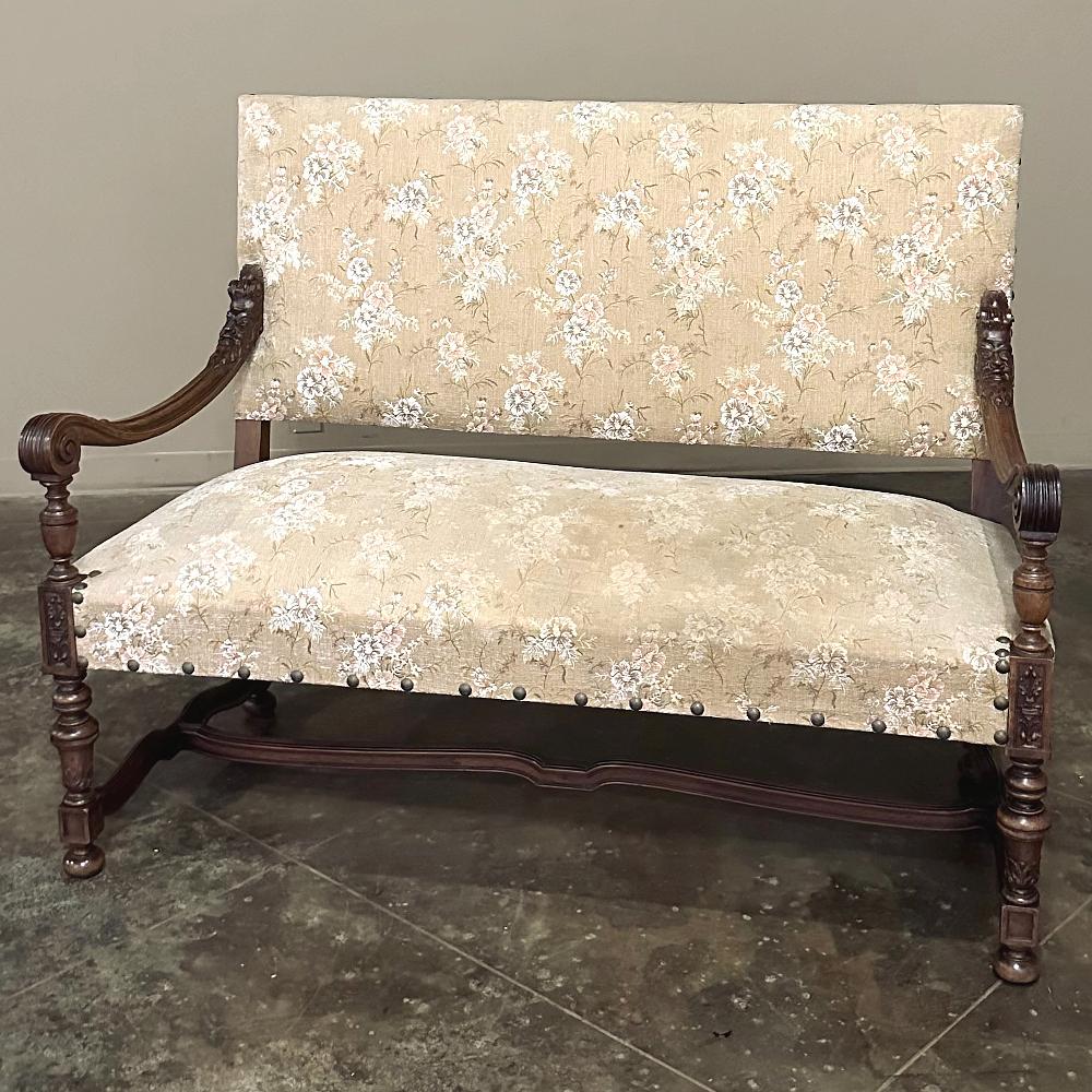 Antique French Louis XIV Walnut Canape ~ Sofa ~ Settee features a tailored neoclassically-inspired architecture evident in the squared seatback and slightly trapezoidal seat shape, with four finely turned legs for support, which are connected via a