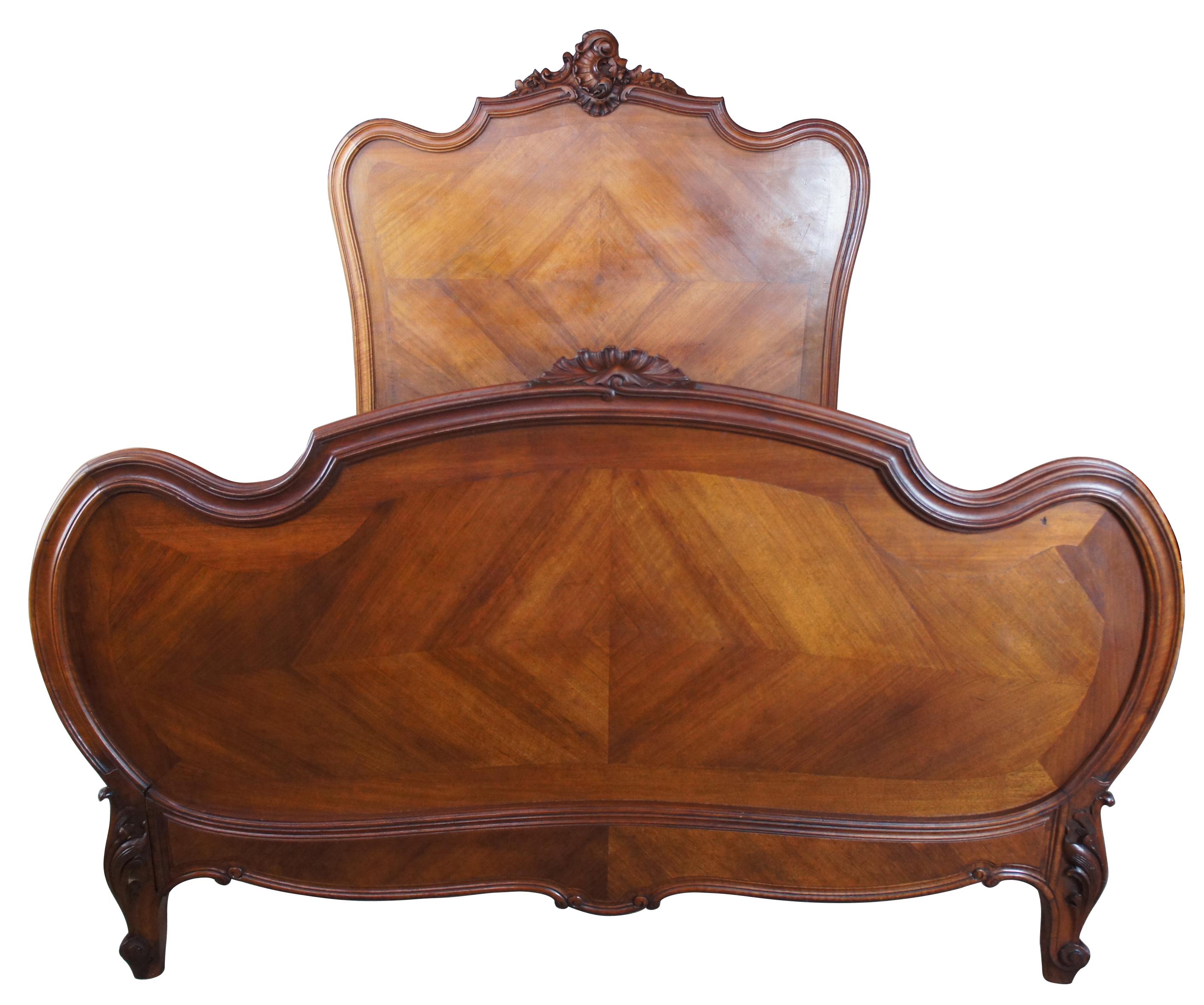 Mid 19th century French or Rococo Revival walnut bed. Features matchbook diamond pattern paneling with thick grooved trim and ornately carved floral and scalloped accents. This bed will fit a full size mattress as long as the box spring or wood