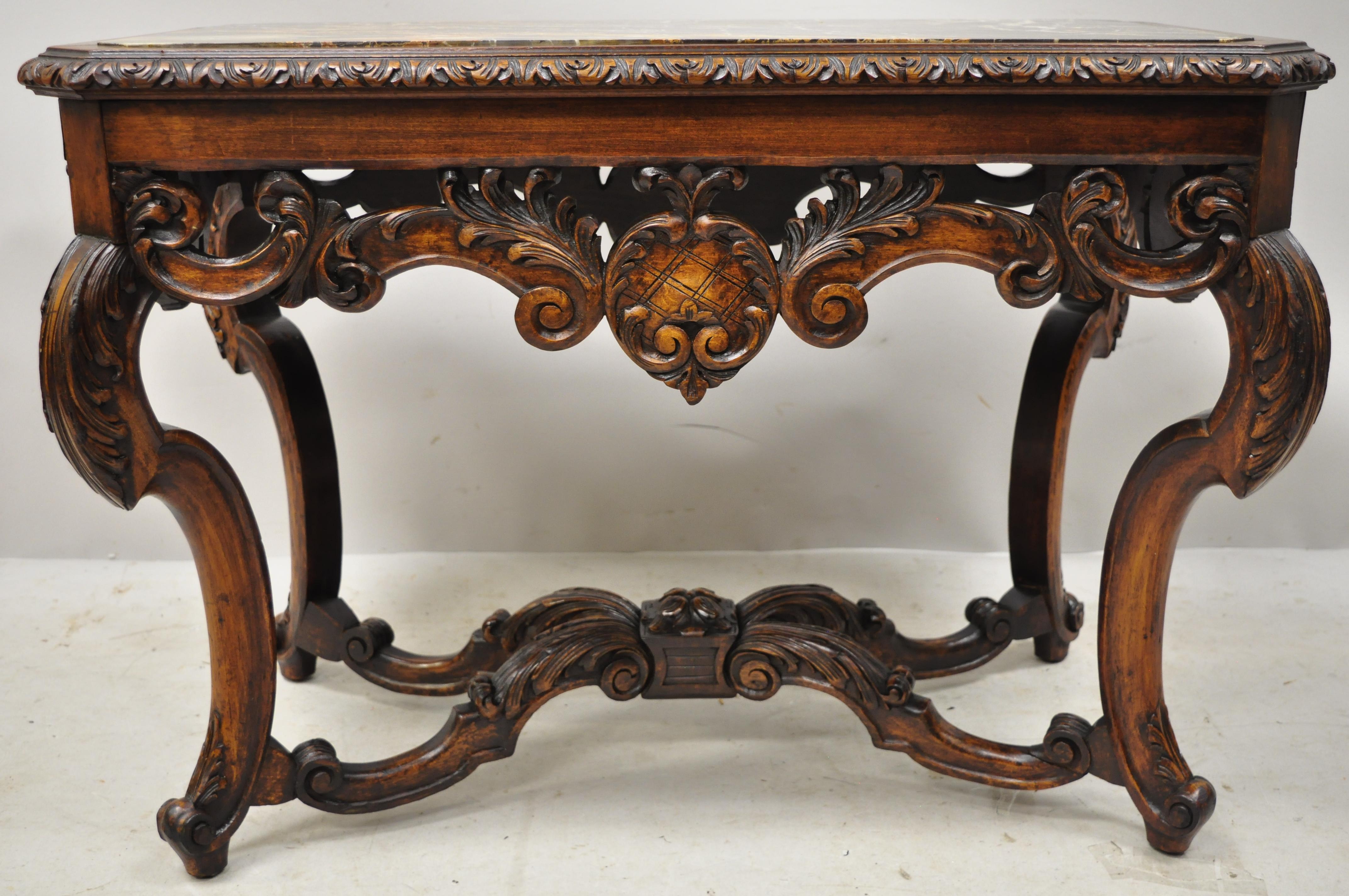 Antique French Louis XV Baroque style carved walnut marble-top small coffee table. Item features a black marble top, ornate scrollwork carved skirt, stretcher base, solid wood construction, beautiful wood grain, nicely carved details, very nice