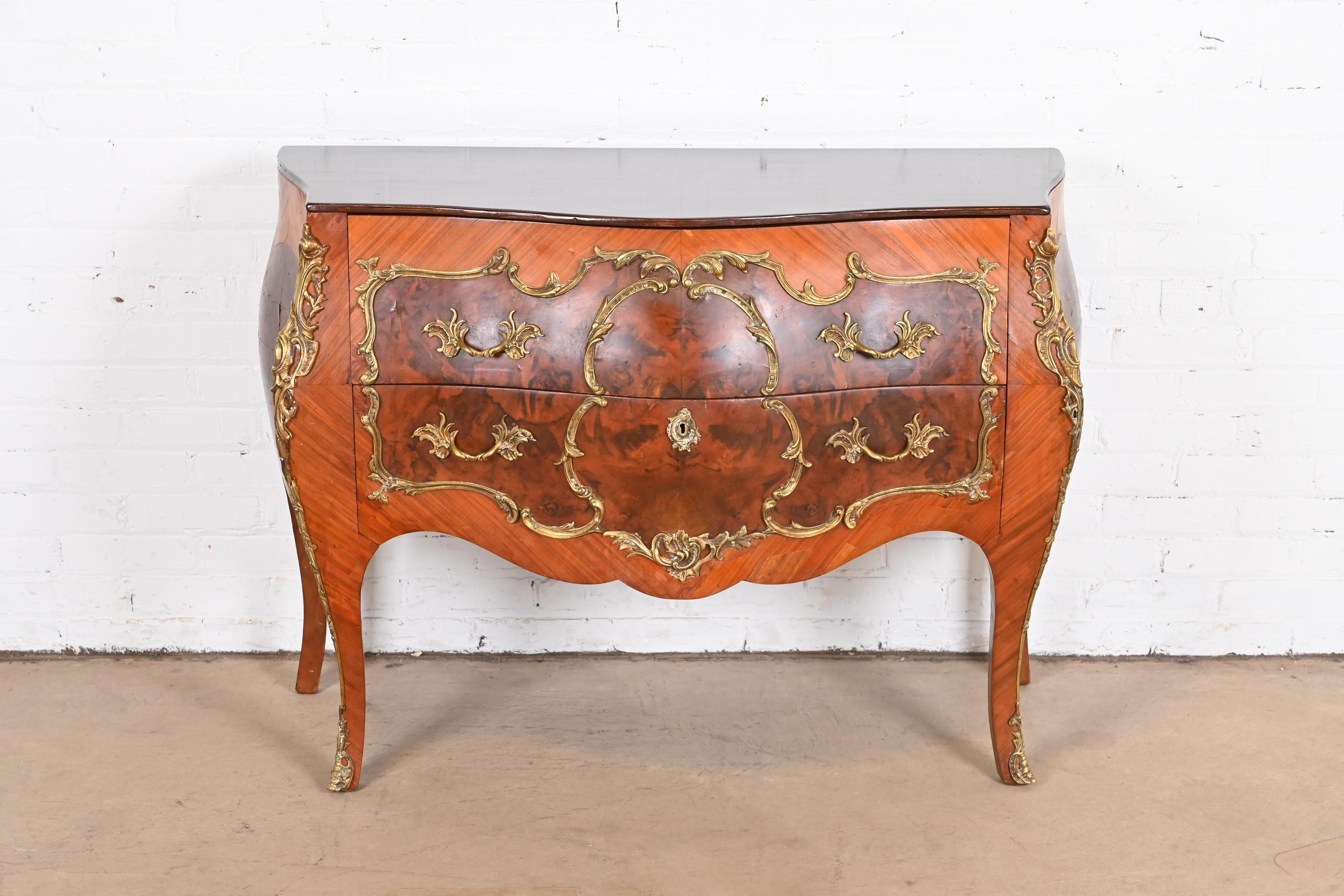 A gorgeous antique French Bombay commode or chest of drawers

France, Early 20th century

Mahogany, with inlaid burled walnut, and mounted bronze ormolu.

Measures: 47