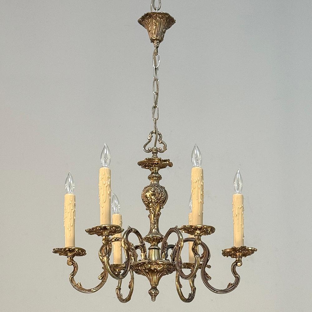 Il lampadario d'ottone Antique French Louis XV porta con sé l'eleganza del Rococò e aggiunge atmosfera a qualsiasi ambiente.  Il fusto centrale principale è a forma di urna e presenta audaci disegni in rilievo di ispirazione barocca su tutto il