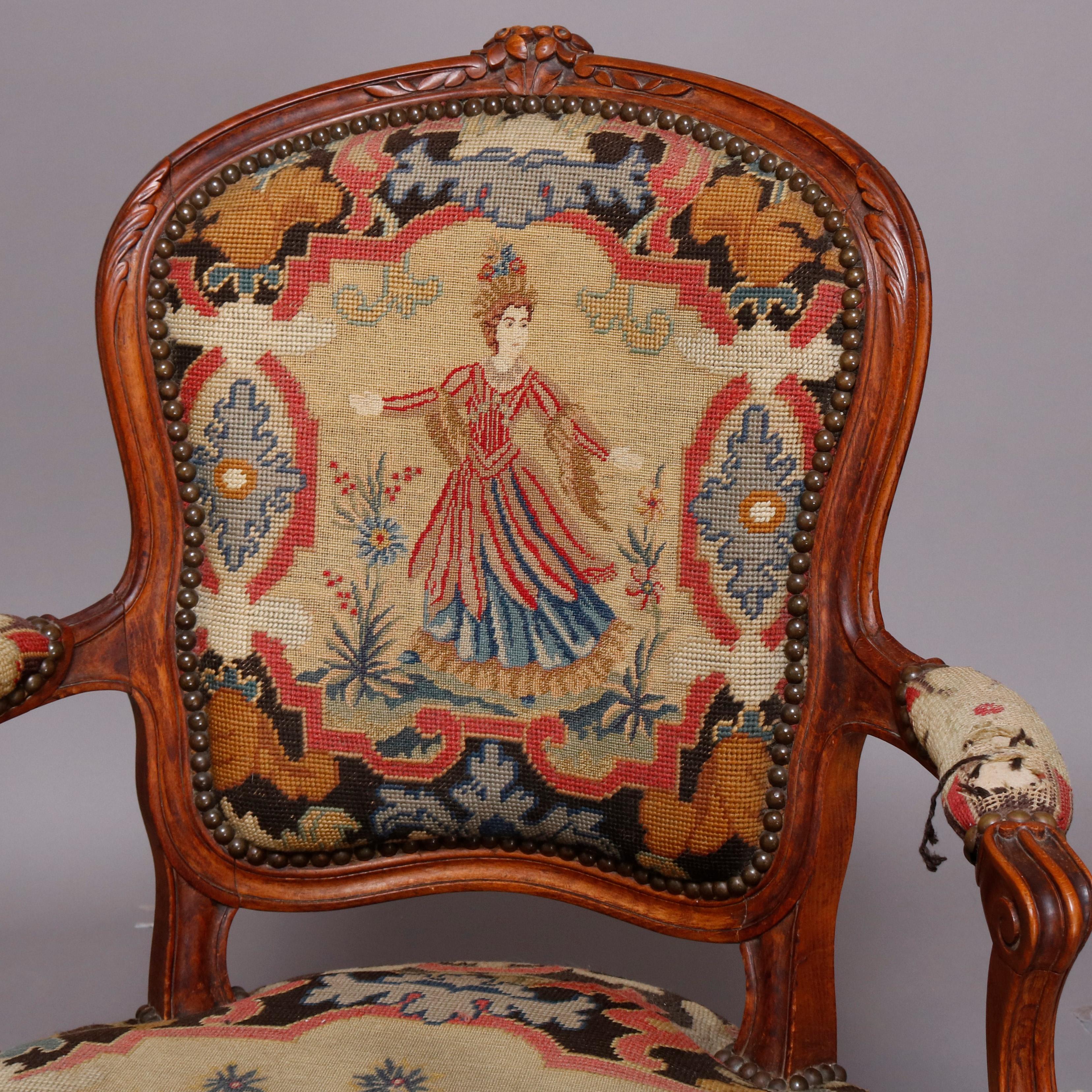 A pair of antique French Louis XV fauteuil offers fruitwood frame with carved floral and foliate crest and skirt, shaped arms and raised on cabriole legs terminating in scroll feet, upholstered in needlepoint with seat having garden scene floral and