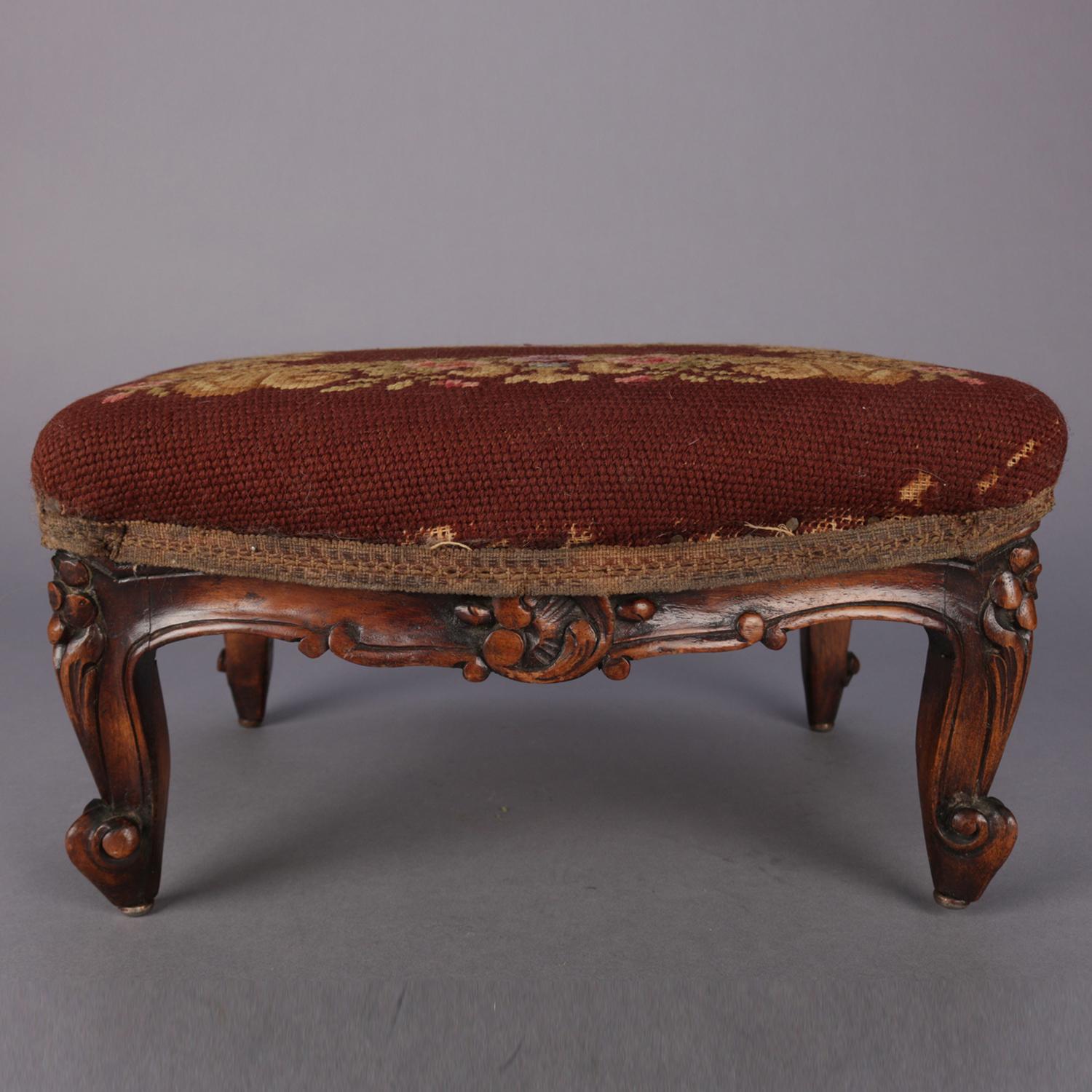 An antique French Louis XV footstool featuring mahogany base having carved foliate, floral and scroll design, raised on cabriole legs terminating in scroll feet, tapestry cushion with needlepoint floral and foliate design, circa 1890.

***DELIVERY