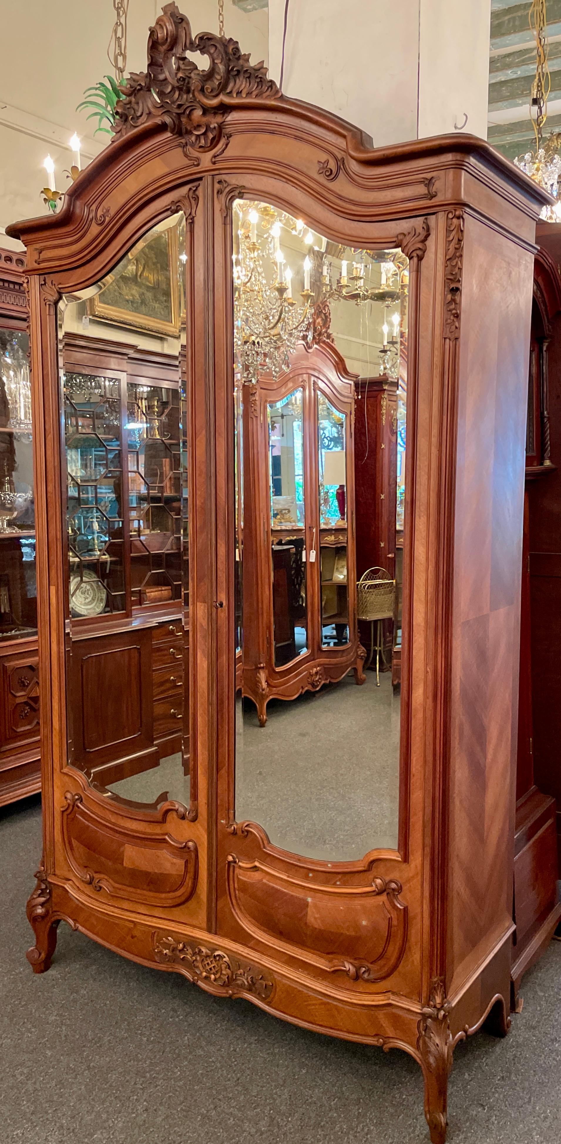 Ancienne armoire française de style Louis XV en noyer sculpté à 2 portes avec miroirs biseautés originaux. Bel intérieur aménagé.
