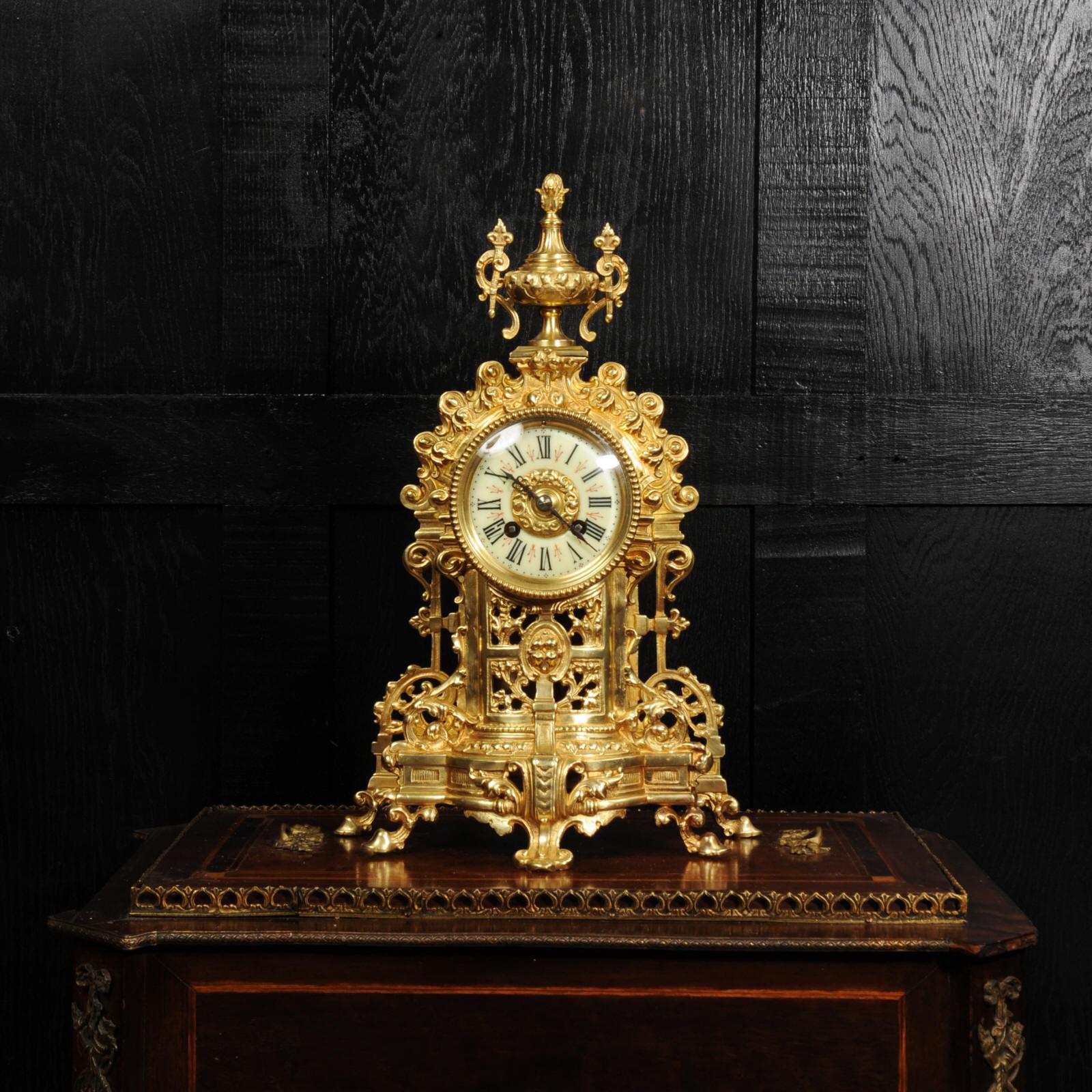 A beautiful antique French gilt bronze clock by A. D. Mougin.  Modelled in architectural form and covered with scrolling acanthus decoration to represent a romantic ruin. To the top is an urn with pineapple finial and handles formed as torches